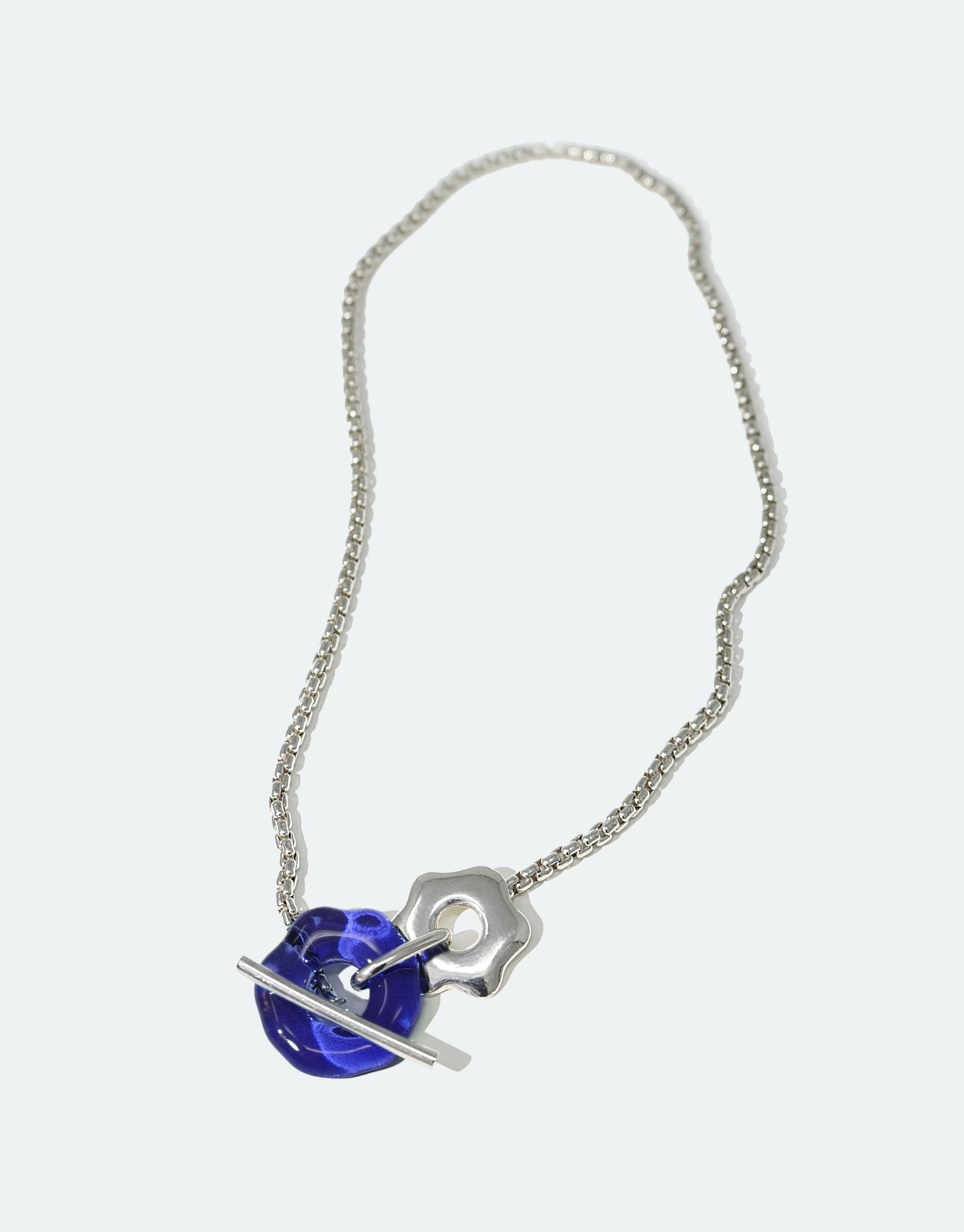 Elegant silver chain necklace with blue glass pendant and abstract toggle closure, inspired by Arctic avens flower. Eco-friendly jewelry showcasing climate change awareness. Avens Toggle Necklace by CLED