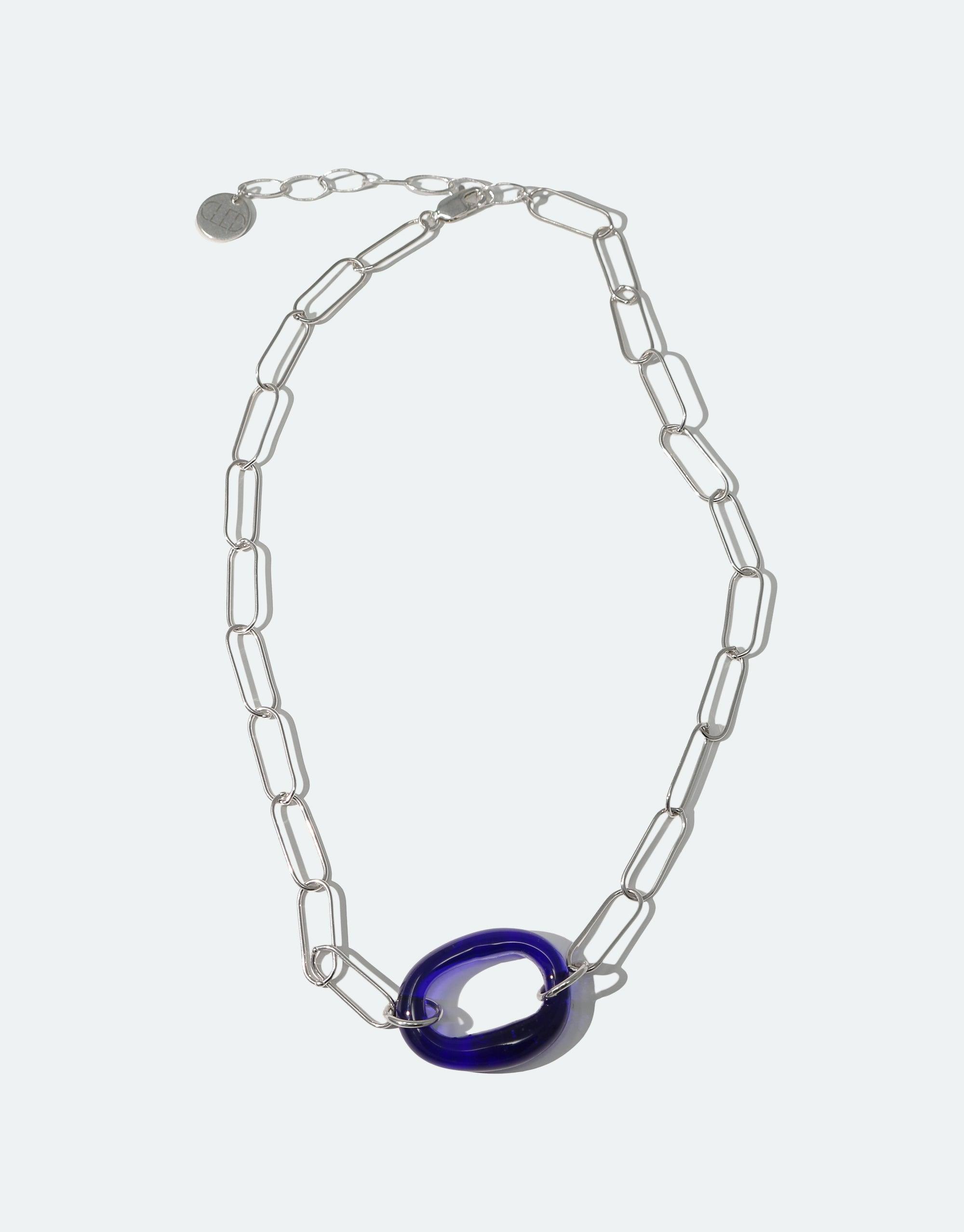 The Day Loop Necklace features hand-formed Eco Gem links from repurposed glass, set in an elegant oval chain with silver accents, embodying eco-conscious craftsmanship from CLED.
