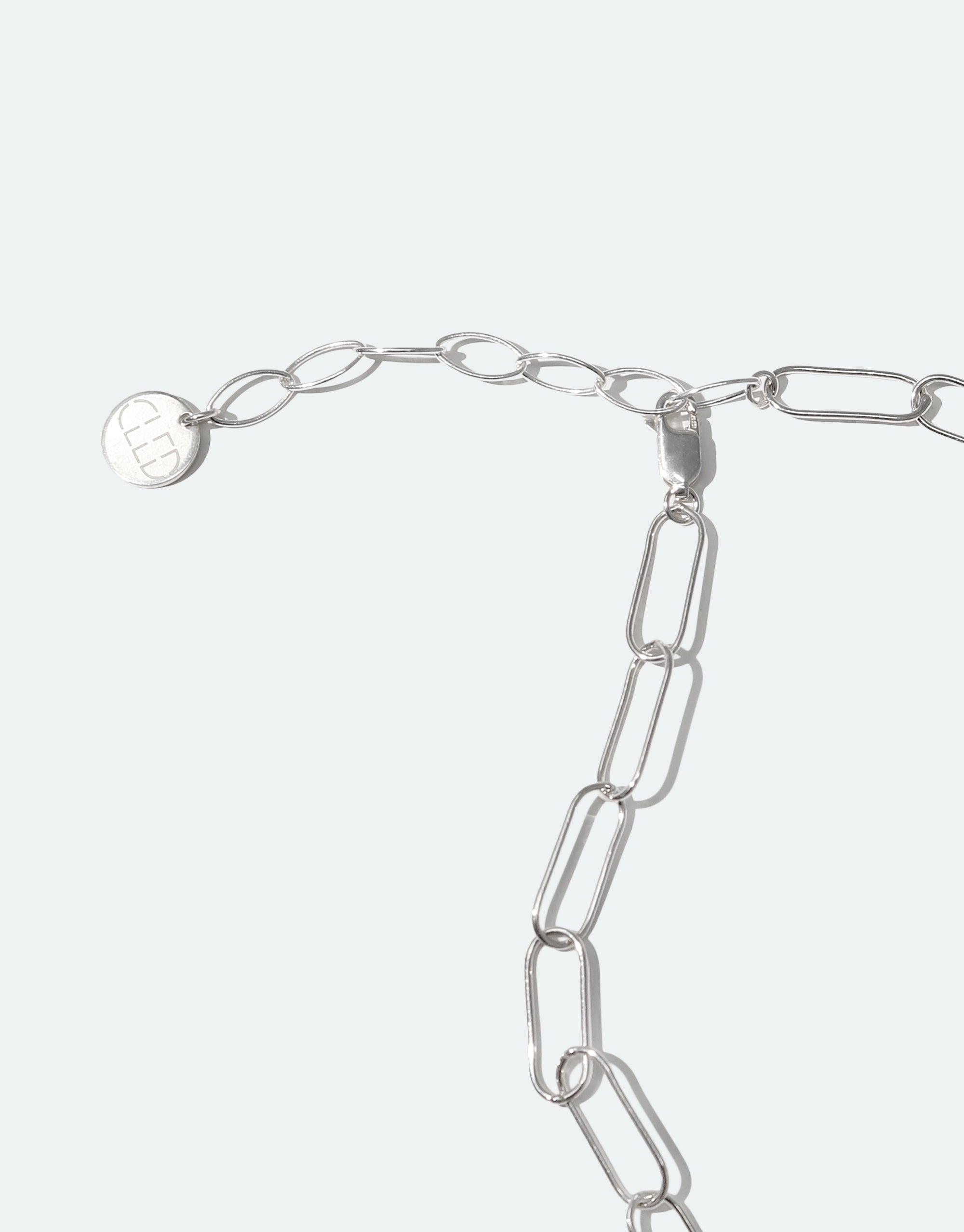 The Day Loop Necklace features a silver chain with an oval design and a round tag, showcasing CLED's eco-conscious craftsmanship with handmade Eco Gems repurposed from discarded glass.