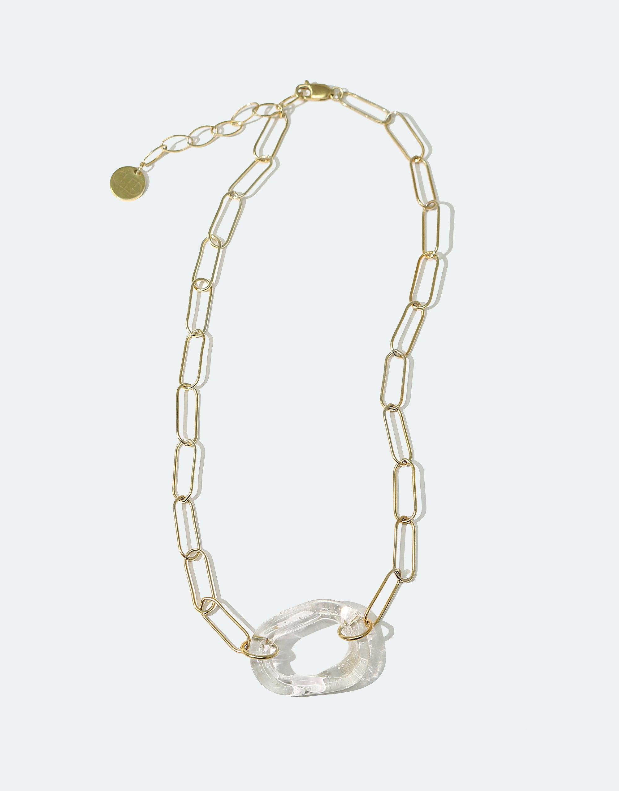 The Day Loop Necklace features a gold chain with a clear pendant, showcasing eco-conscious craftsmanship with a minimal design ideal for layering, made from repurposed glass.