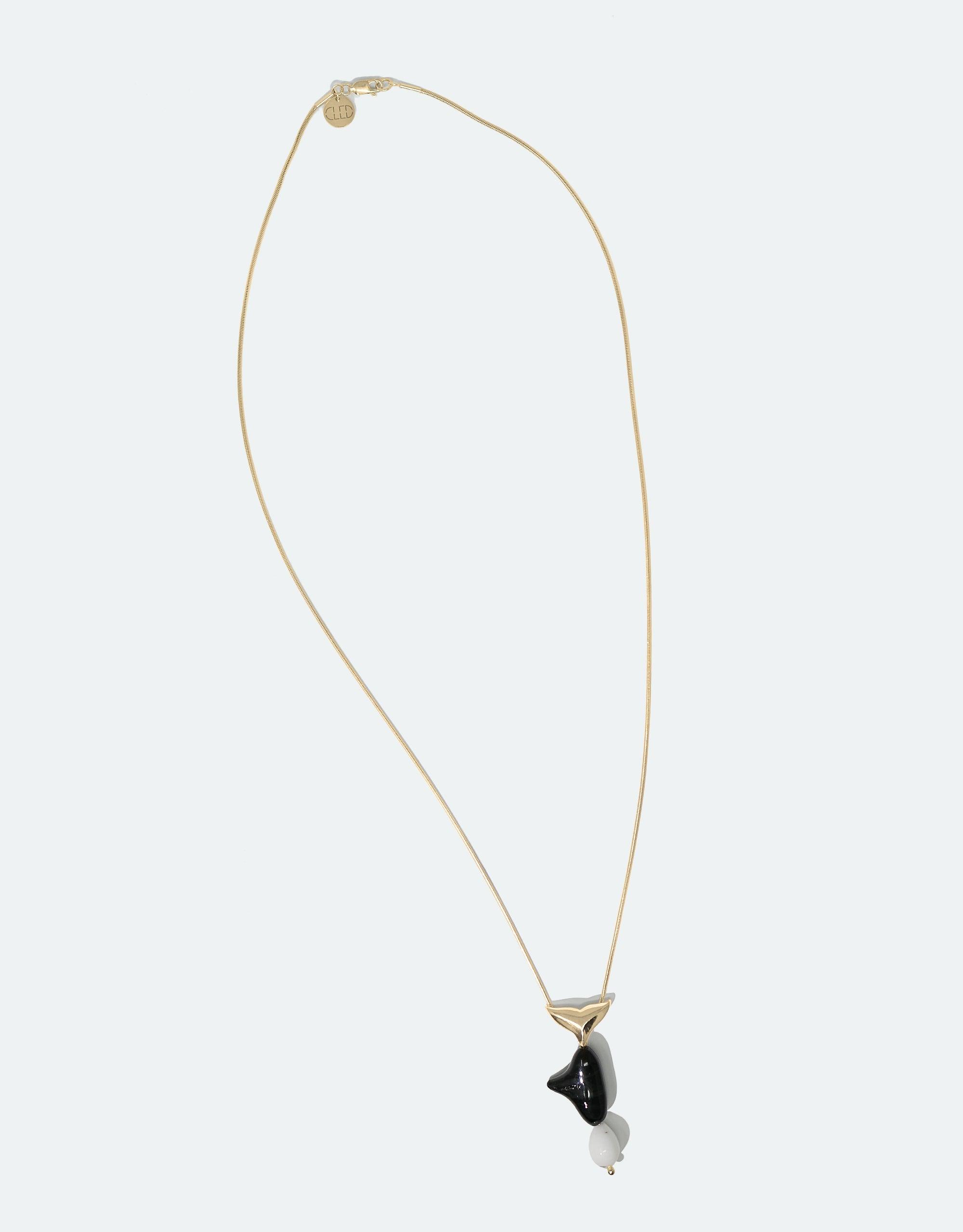 Elegant gold chain necklace featuring a stylized orca pendant made from repurposed black and white glass, part of the Floating Glacier Collection. Orca Necklace showcases eco-friendly design and raises awareness for endangered marine life. CLED