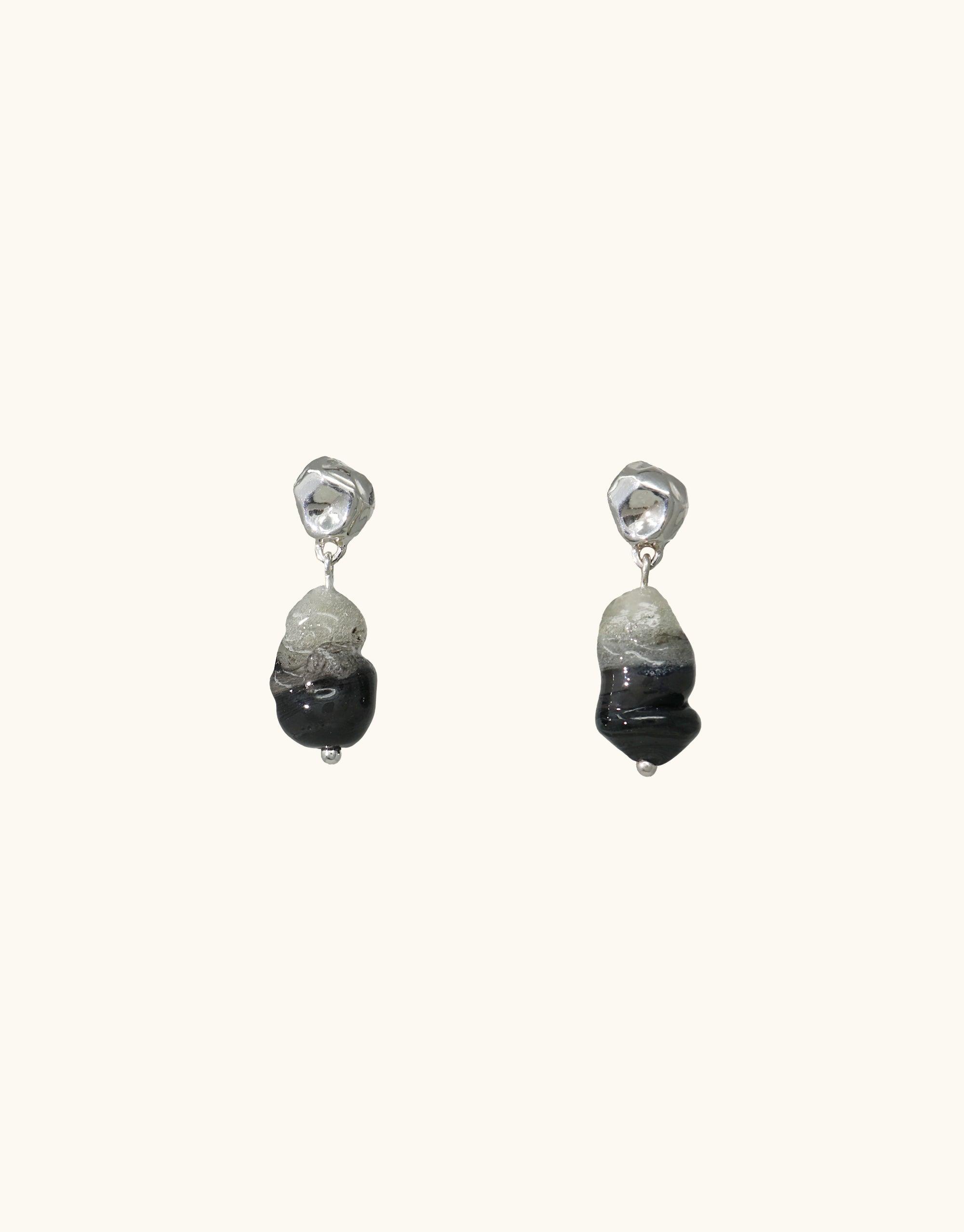 Handcrafted Shades of Nature Basalt Earrings featuring abstract molten forms in gradient black hues, inspired by Icelandic volcanic canyons. Sterling silver studs with eco-friendly glass elements. Elegant, nature-inspired jewelry piece from the Terrain Collection. CLED Shades of Nature | Basalt Earrings