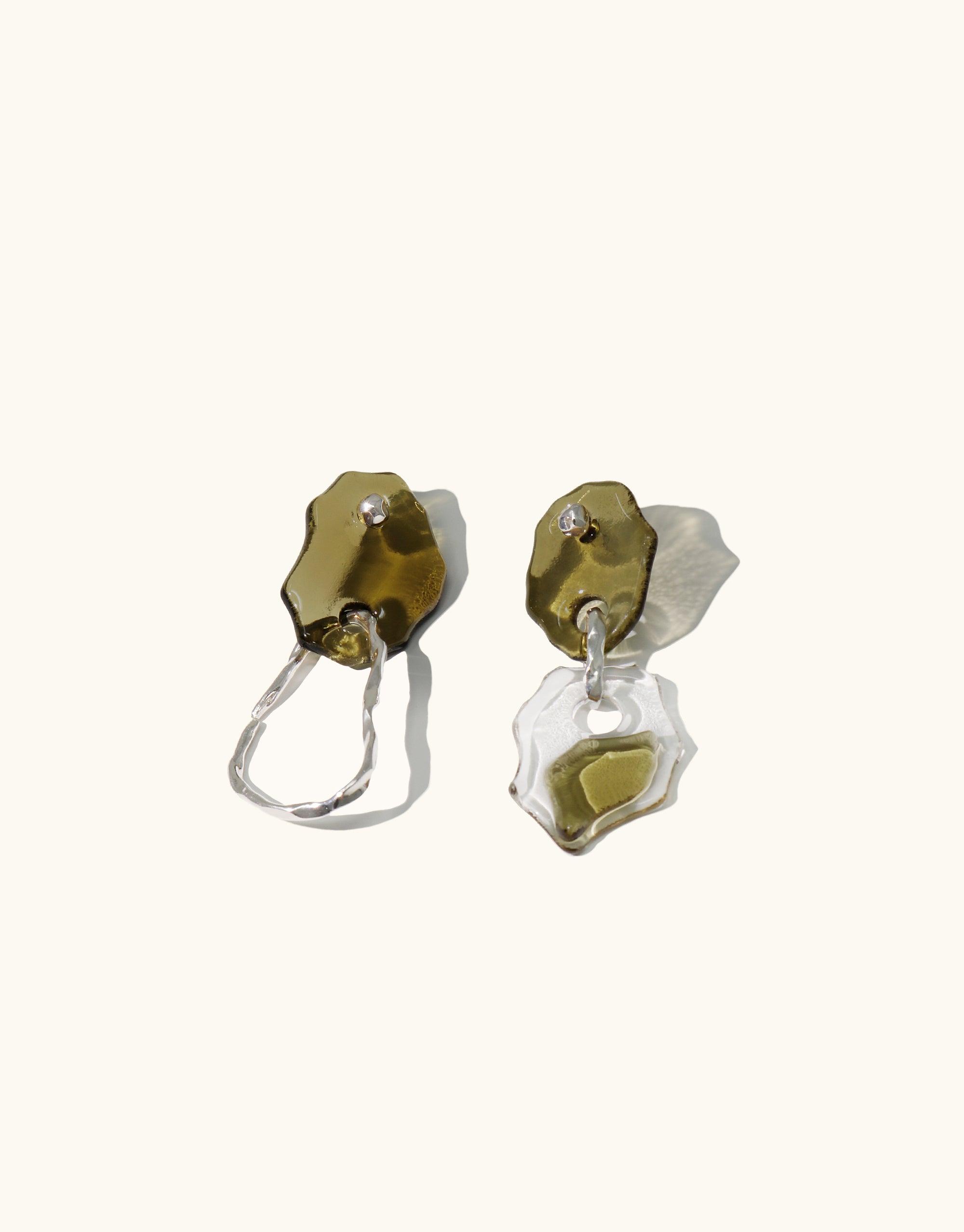 Handcrafted Peak Earrings featuring mismatched design with layered glass charms in olive green and clear, inspired by canyon terrain. Sterling silver hooks. Eco-friendly jewelry made from repurposed glass bottles. Unique, abstract molten forms. Terrain Collection by CLED.