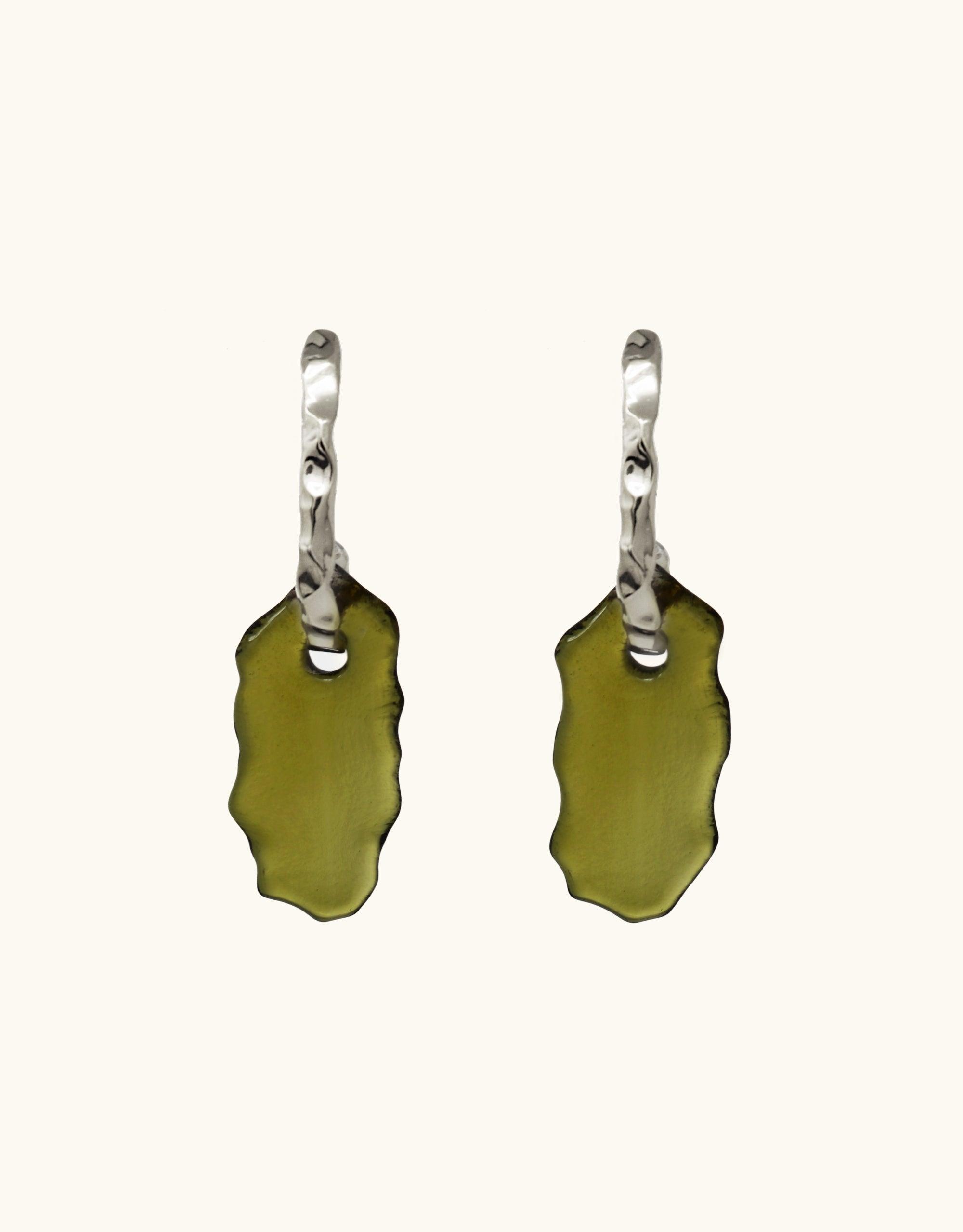 Elegant Rock Spire Earrings featuring twisted silver hoops with olive green glass drops, inspired by canyon formations. Handcrafted eco-friendly jewelry made from repurposed glass bottles. Unique statement pieces from the Terrain Collection by CLED.