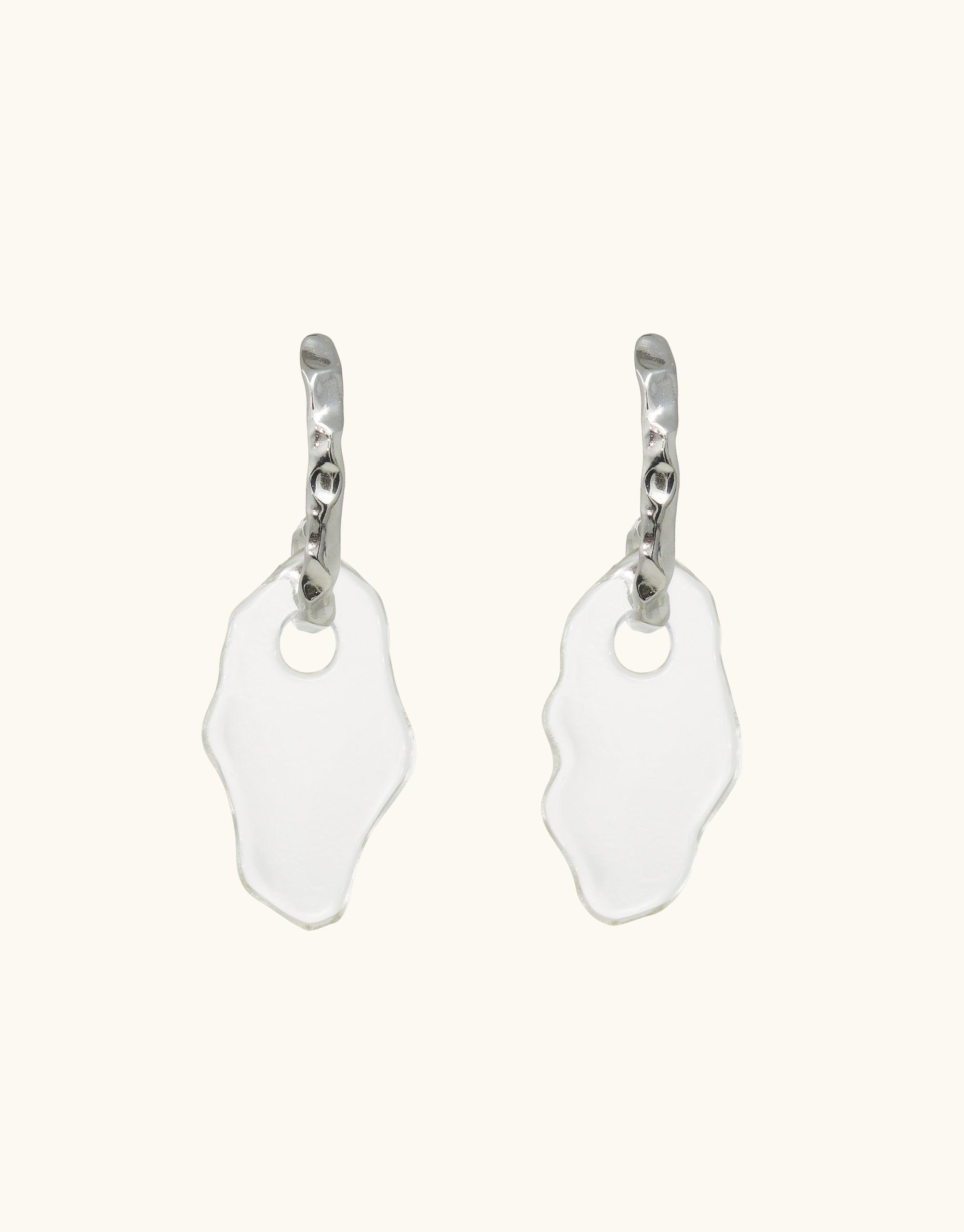 Rock Spire Earrings featuring curved silver hoops with irregular-shaped clear glass drops, inspired by canyon terrain. Handcrafted eco-friendly jewelry made from repurposed glass bottles. Statement piece from the Terrain Collection by CLED.