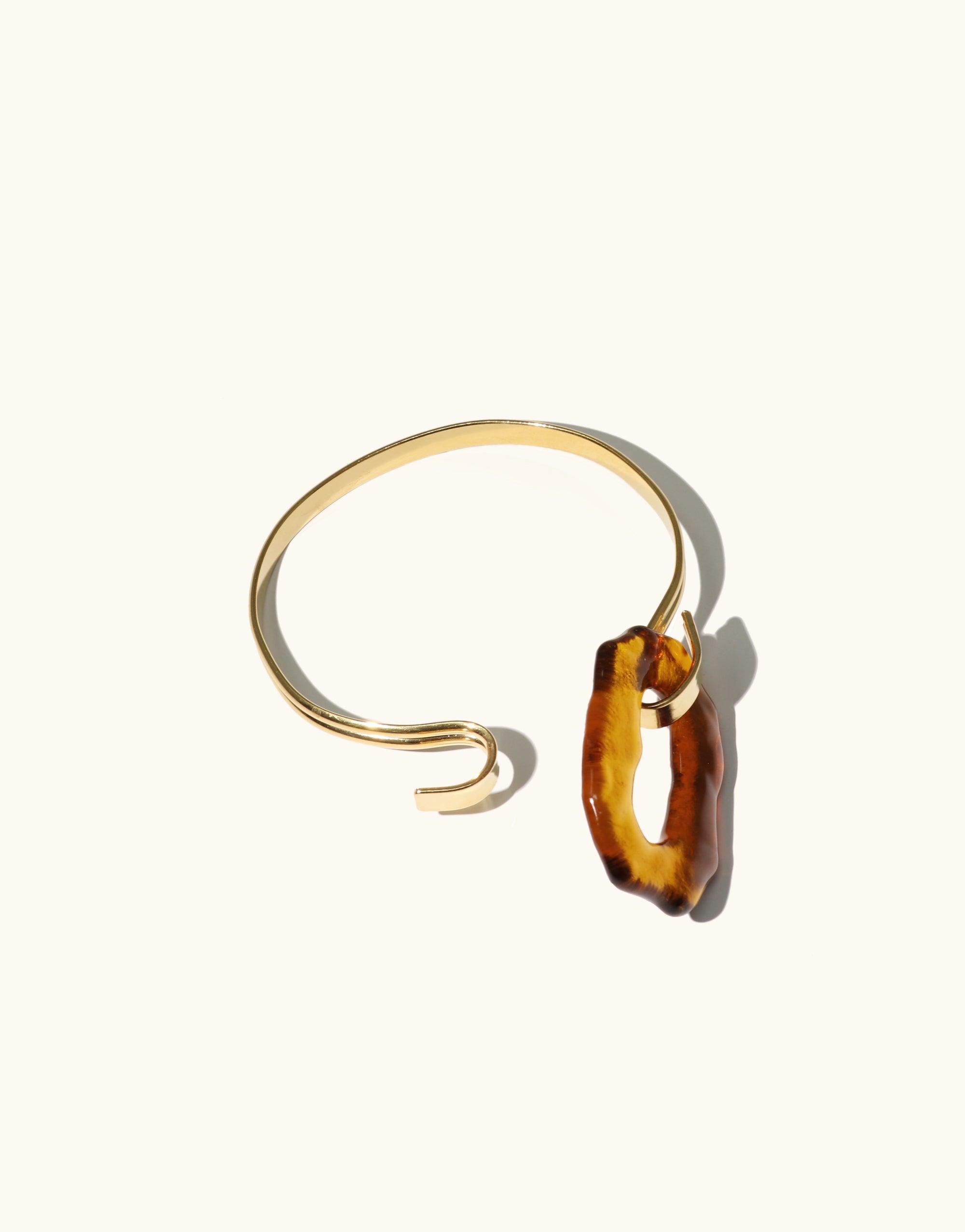 Elegant gold-toned Canyon Hook Bracelet with amber-colored glass eco gem, inspired by canyon terrain. Unique open-ended design with hook closure. Handcrafted sustainable jewelry piece from the Terrain Collection by CLED.