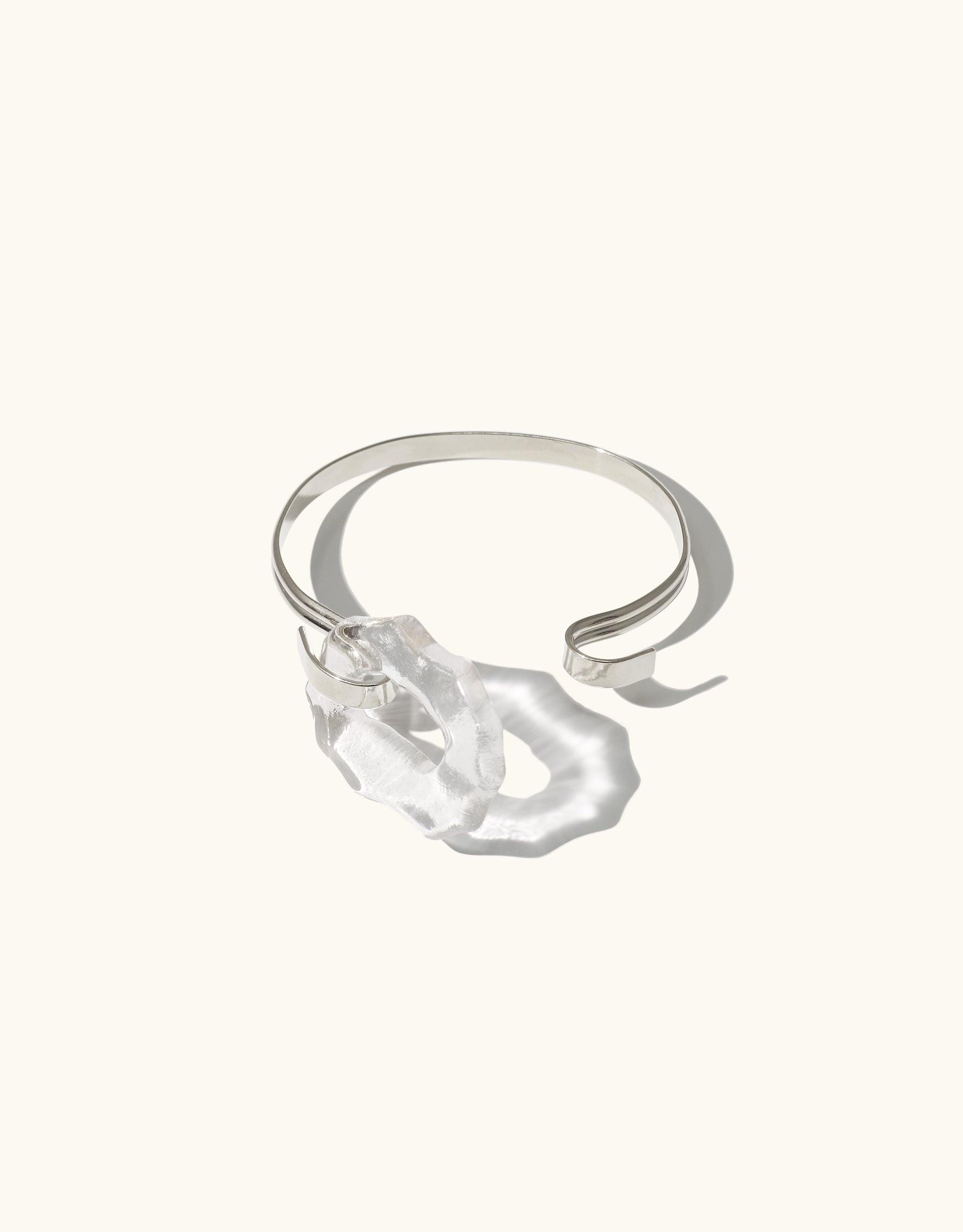 Canyon Hook Bracelet featuring a unique organic glass shape on a sleek silver band, inspired by canyon terrain. Handcrafted eco-friendly jewelry piece with an adjustable hook closure. Sustainable and stylish accessory by CLED.