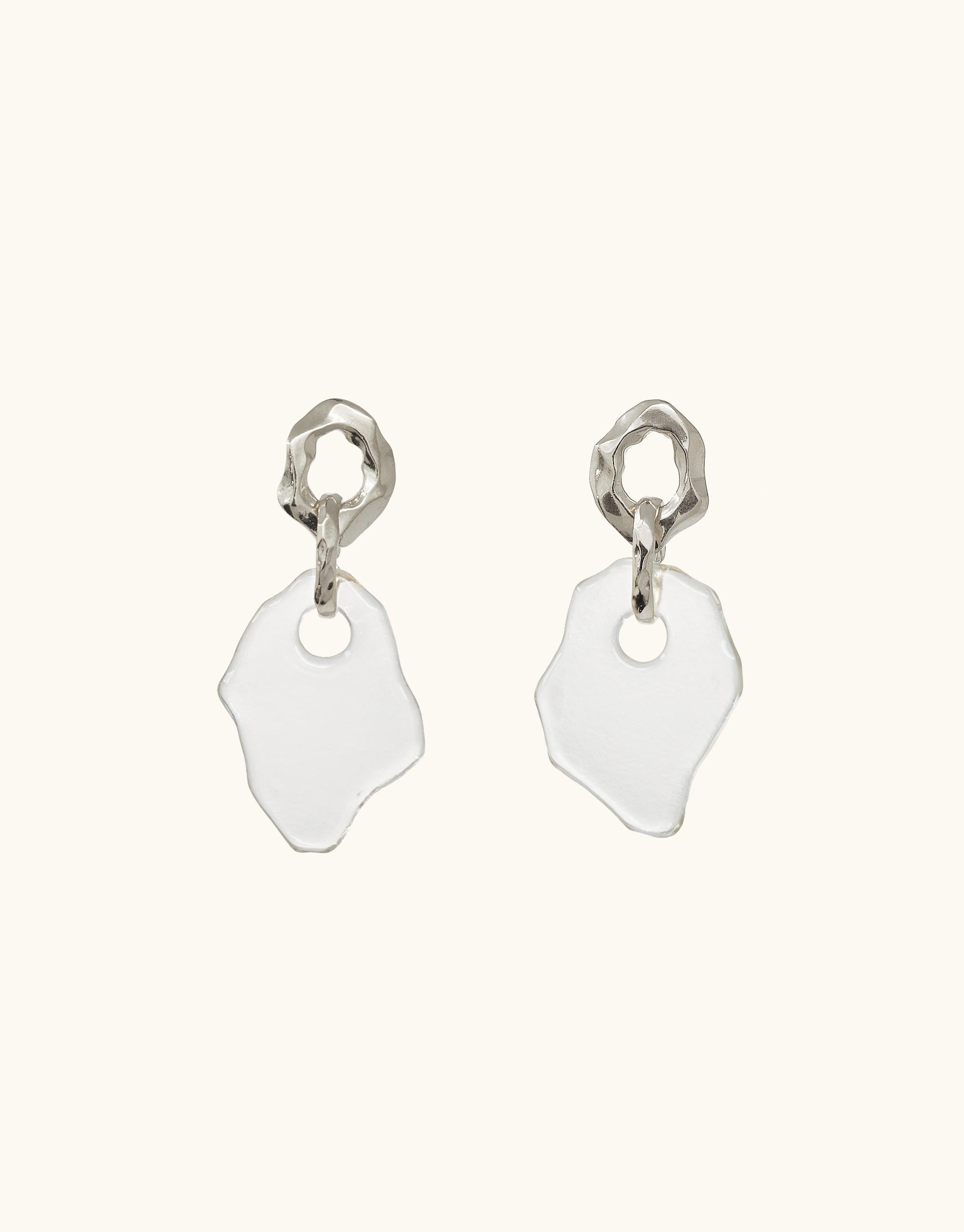 Canyon Earrings featuring organic-shaped silver studs with irregular white glass pendants, inspired by canyon terrain. Handcrafted earrings showcasing eco-friendly recycled glass and abstract molten forms. Stylish, sustainable jewelry from the Terrain Collection by CLED.