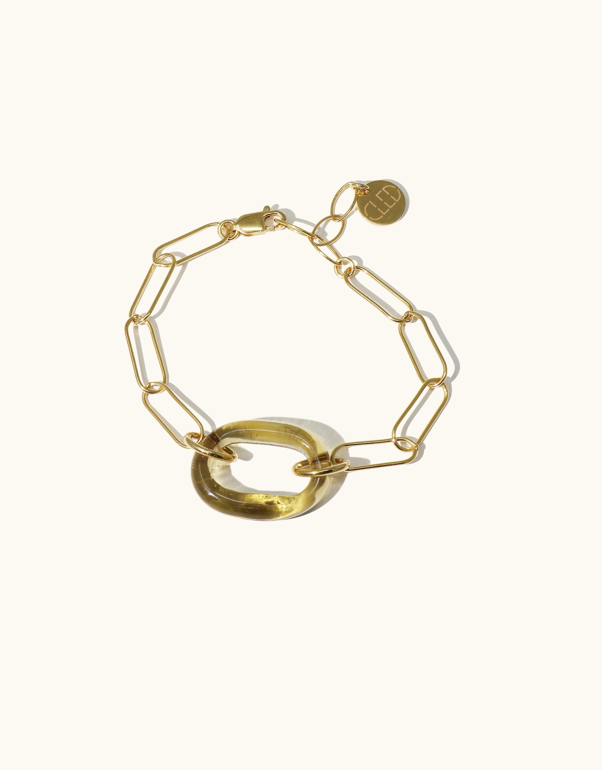 The Day Loop Bracelet features a gold vermeil oval chain with a hand-formed Eco Gem, crafted from repurposed glass, creating a minimalist yet elegant statement piece.
