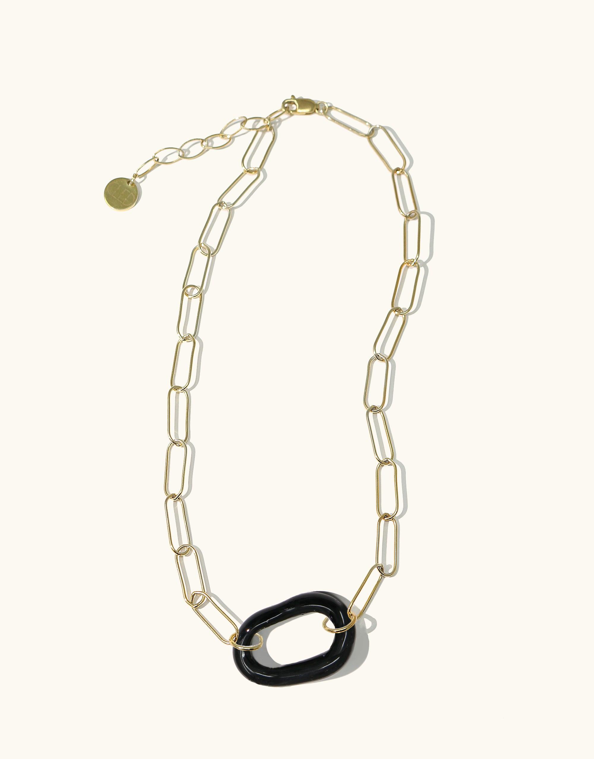 The Day Loop Necklace features a gold paperclip chain with a black oval Eco Gem pendant, hand-formed from repurposed glass, embodying CLED's eco-conscious craftsmanship.
