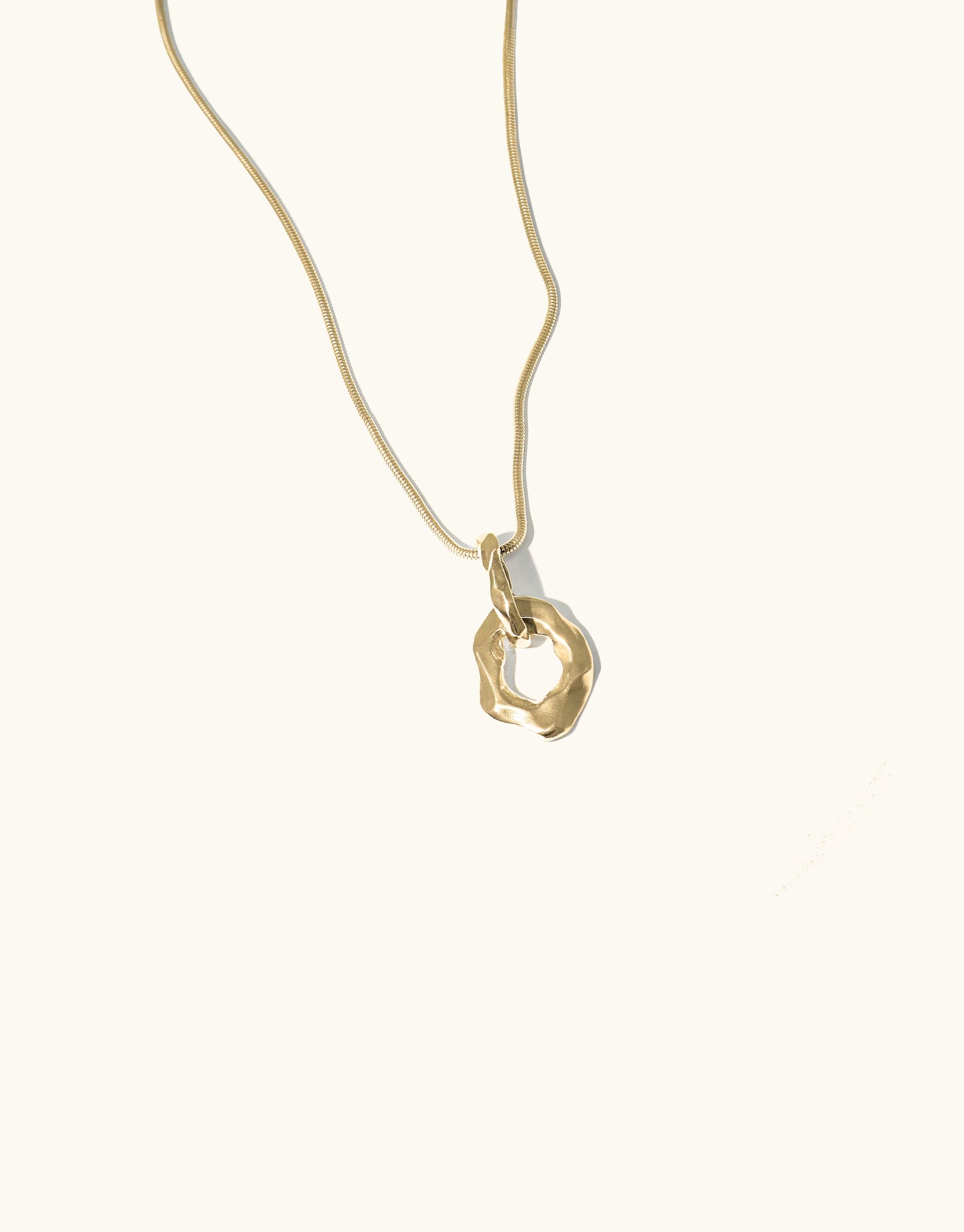 Canyon Necklace featuring a gold-toned chain with an abstract, molten-shaped pendant inspired by canyon terrain. The unique, smooth curved design showcases the Terrain Collection's artistic interpretation of natural formations. Handcrafted in Los Angeles by CLED.