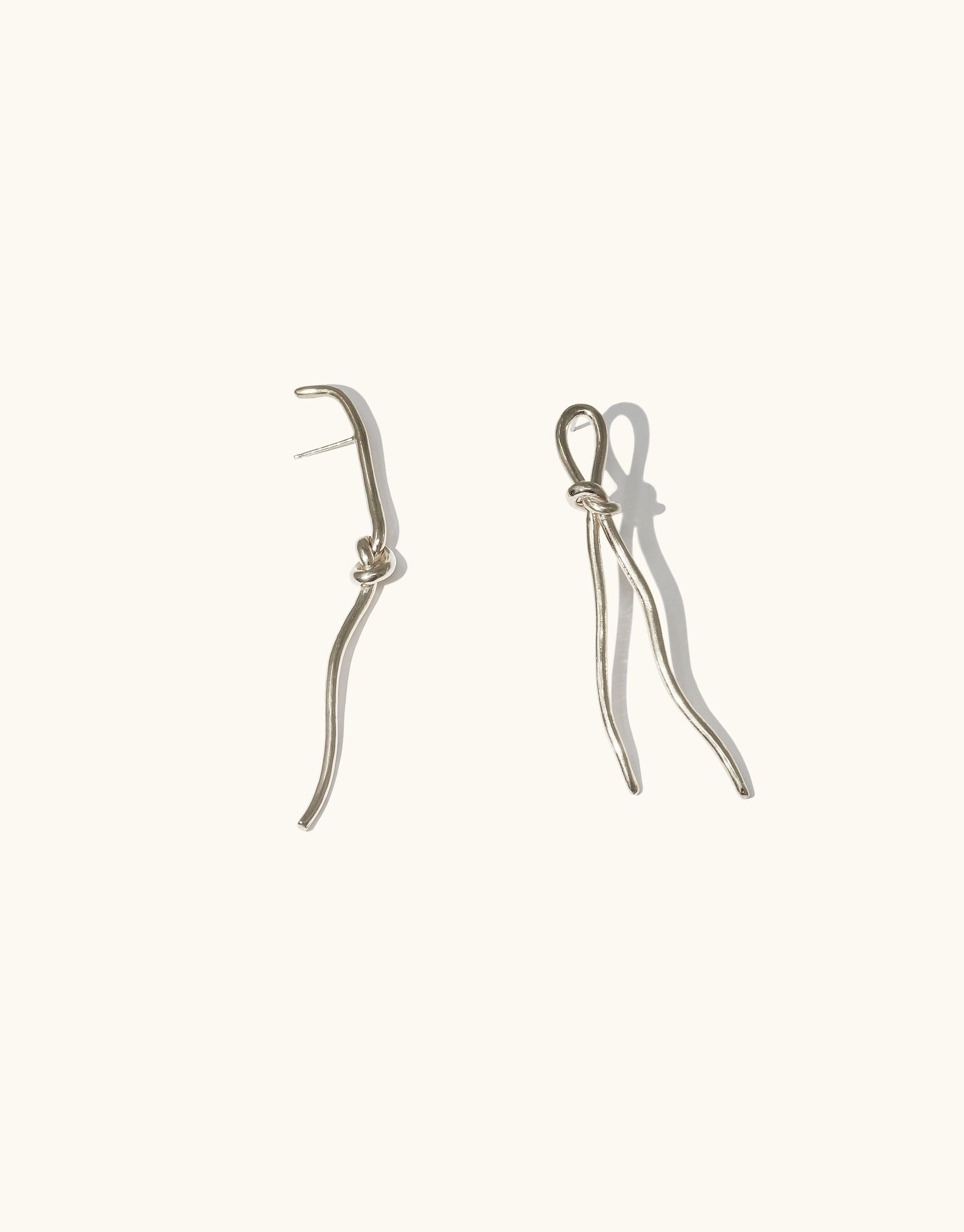 Elegant silver Rope Earrings featuring unique curved designs inspired by canyon terrain and rock climbing tools. Handcrafted asymmetrical shapes for a stylish, contemporary look. Part of the Terrain Collection by CLED.