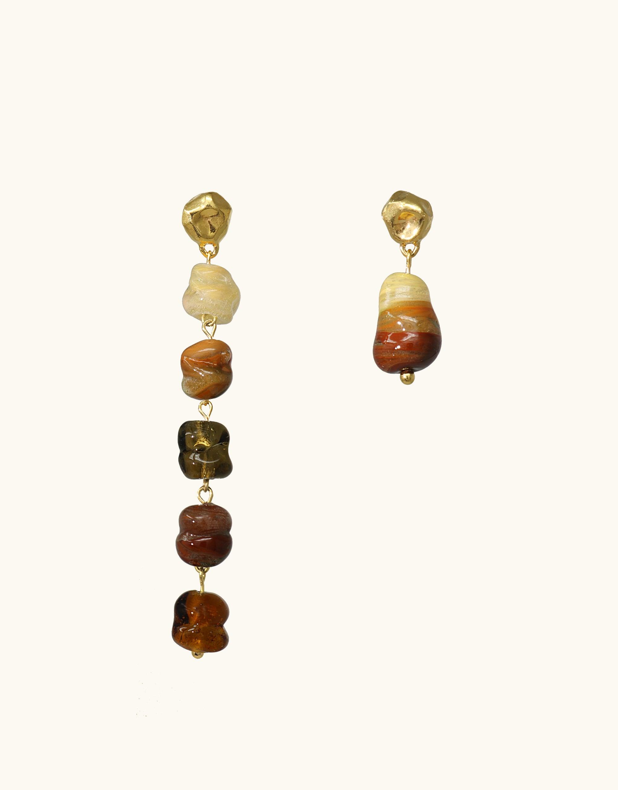 Asymmetrical gold earrings with irregular sandstone-colored glass beads in varying shades of brown and amber, showcasing a unique canyon-inspired design. Shades of Nature | Sandstone Earrings by CLED