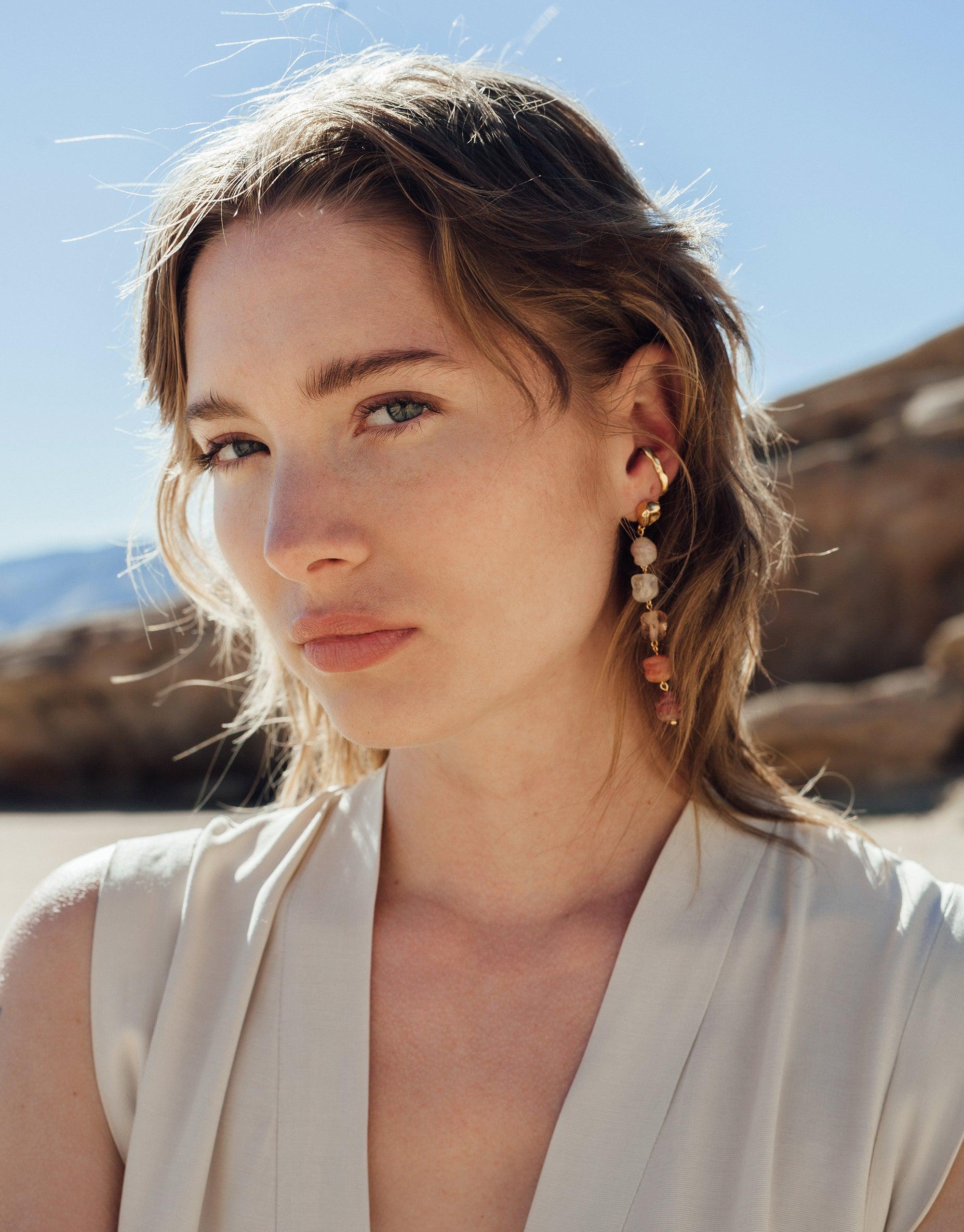 Stylish woman wearing Rock Ear Cuff from Terrain Collection in desert setting, showcasing minimal canyon-inspired jewelry design. Handcrafted sterling silver or gold vermeil accessory perfect for layering. Rock Ear Cuff | Single by CLED
