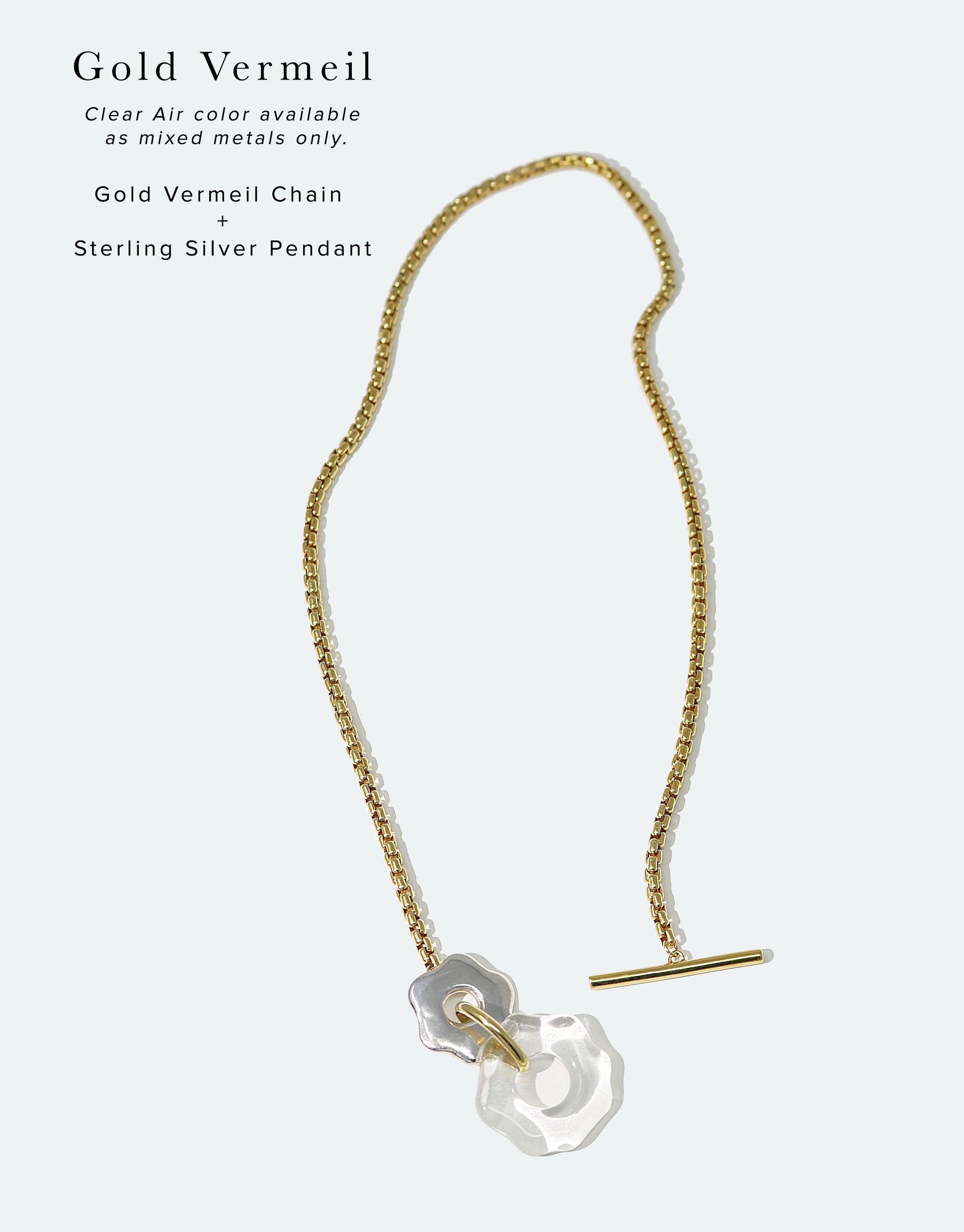 Avens Toggle Necklace featuring gold vermeil chain with sterling silver pendant. Clear eco gem from recycled glass bottles. Elegant design inspired by Arctic flora. Versatile toggle closure. Handcrafted sustainable jewelry by CLED.