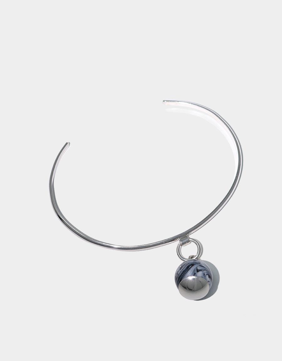 Drop Bracelet: Elegant sterling silver cuff with minimalist design featuring a suspended marble-like glass gem. Handcrafted bracelet showcasing a repurposed glass drop, embodying sustainable luxury. Sleek and contemporary accessory perfect for everyday wear. CLED