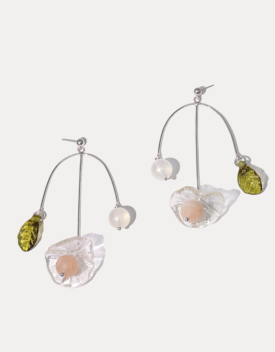 Floral Cluster Earrings featuring delicate sterling silver arches adorned with transparent flowers, peach-colored centers, white beads, and green accents. Handcrafted, eco-friendly design showcasing unique textures and colors. Perfect for spring and summer fashion. CLED Floral Cluster Earrings.
