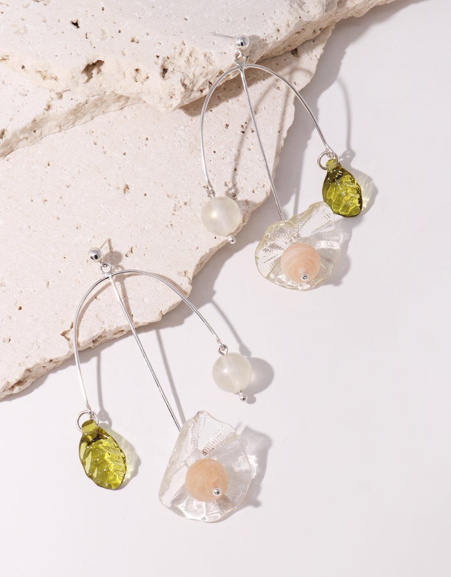 Floral Cluster Earrings featuring delicate sterling silver hooks with three unique pendants: a translucent white bead, a green eco-glass teardrop, and a clear floral-shaped charm with a soft pink center. Handcrafted sustainable jewelry by CLED.