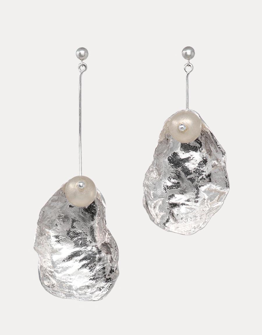 Sustainable dangle earrings featuring eco-friendly glass pearls set in textured metal shells, hanging from sterling silver posts. Handcrafted sustainable jewelry showcasing recycled materials. Not A Pearl Earring by CLED.