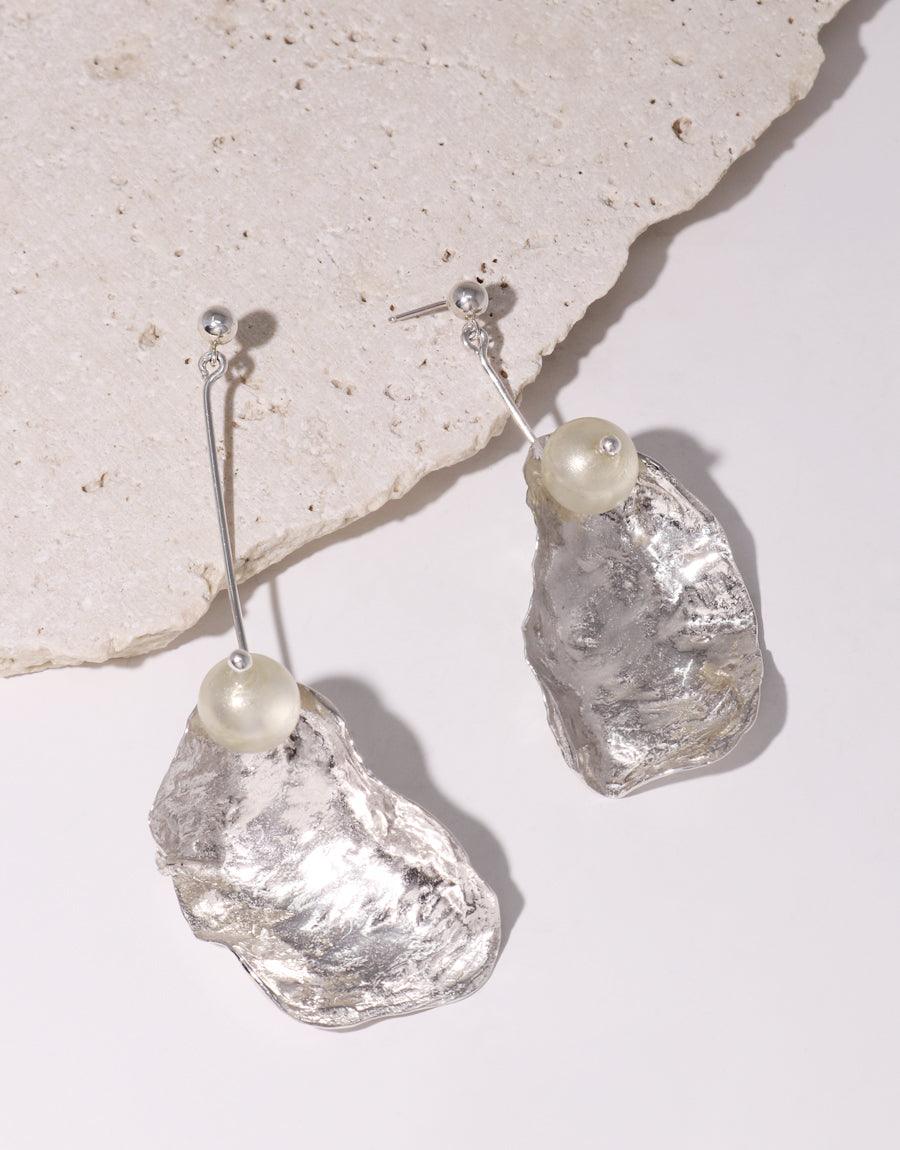 Elegant "Not A Pearl Earring" featuring sustainable Eco Gems dangling from sterling silver posts. Textured metal shells gleam with a pearlescent finish. Handcrafted from recycled glass bottles, these vegan earrings offer an eco-friendly alternative to traditional pearls. CLED