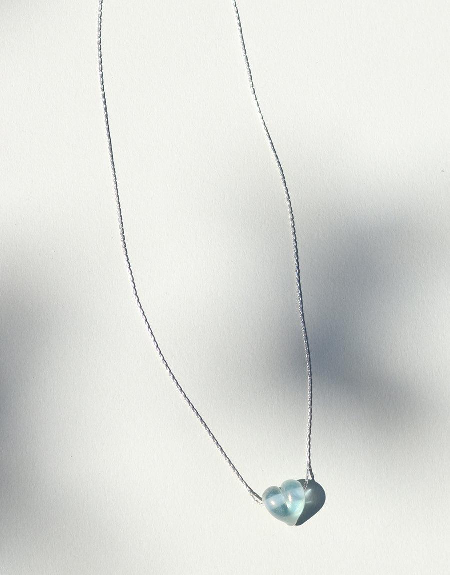 Delicate sterling silver chain featuring a handcrafted heart-shaped pendant made from repurposed glass. Elegant and minimalist Love Necklace design showcasing sustainable craftsmanship. Perfect for expressing affection. Customizable colors available. Handmade in Los Angeles by CLED.