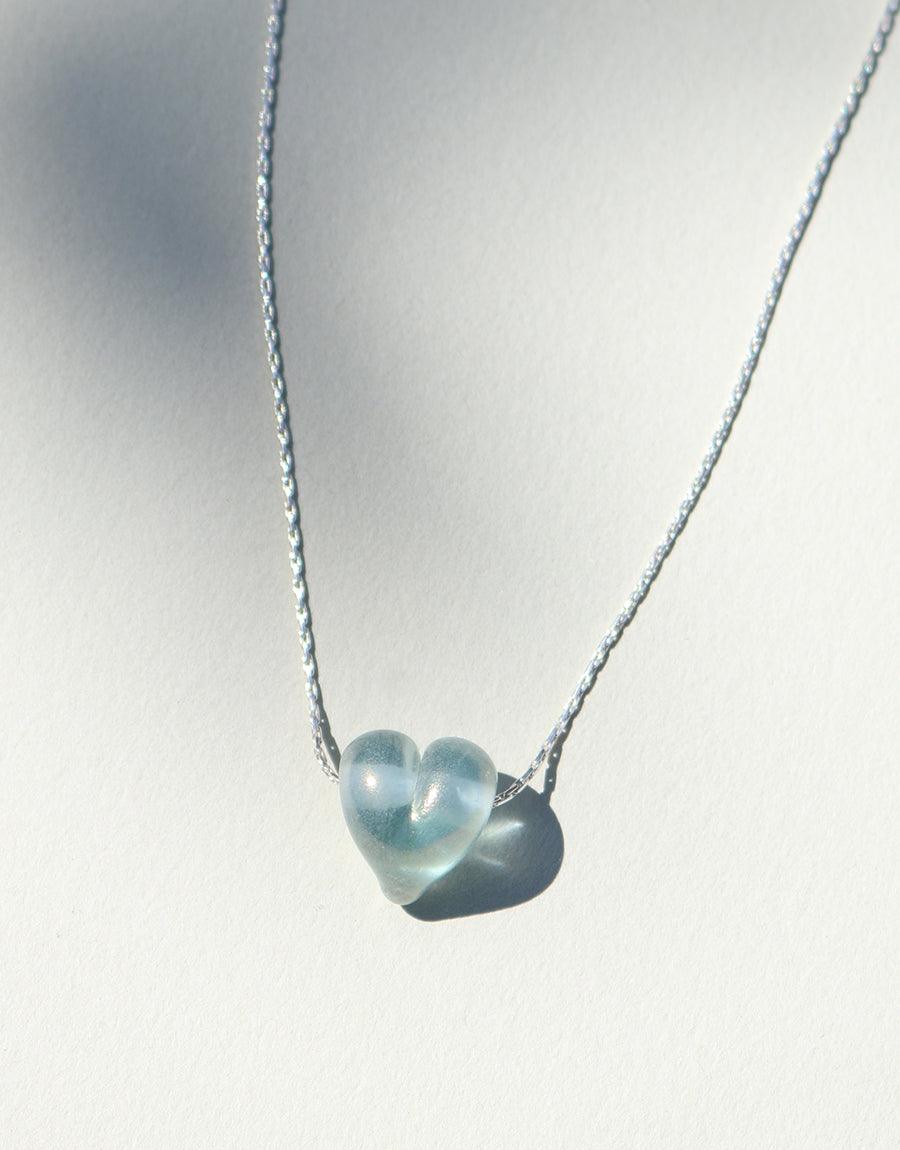 Delicate sterling silver chain featuring a translucent blue heart-shaped pendant made from repurposed glass. Elegant Love Necklace showcasing sustainable craftsmanship and minimalist design. Handcrafted in Los Angeles by CLED.