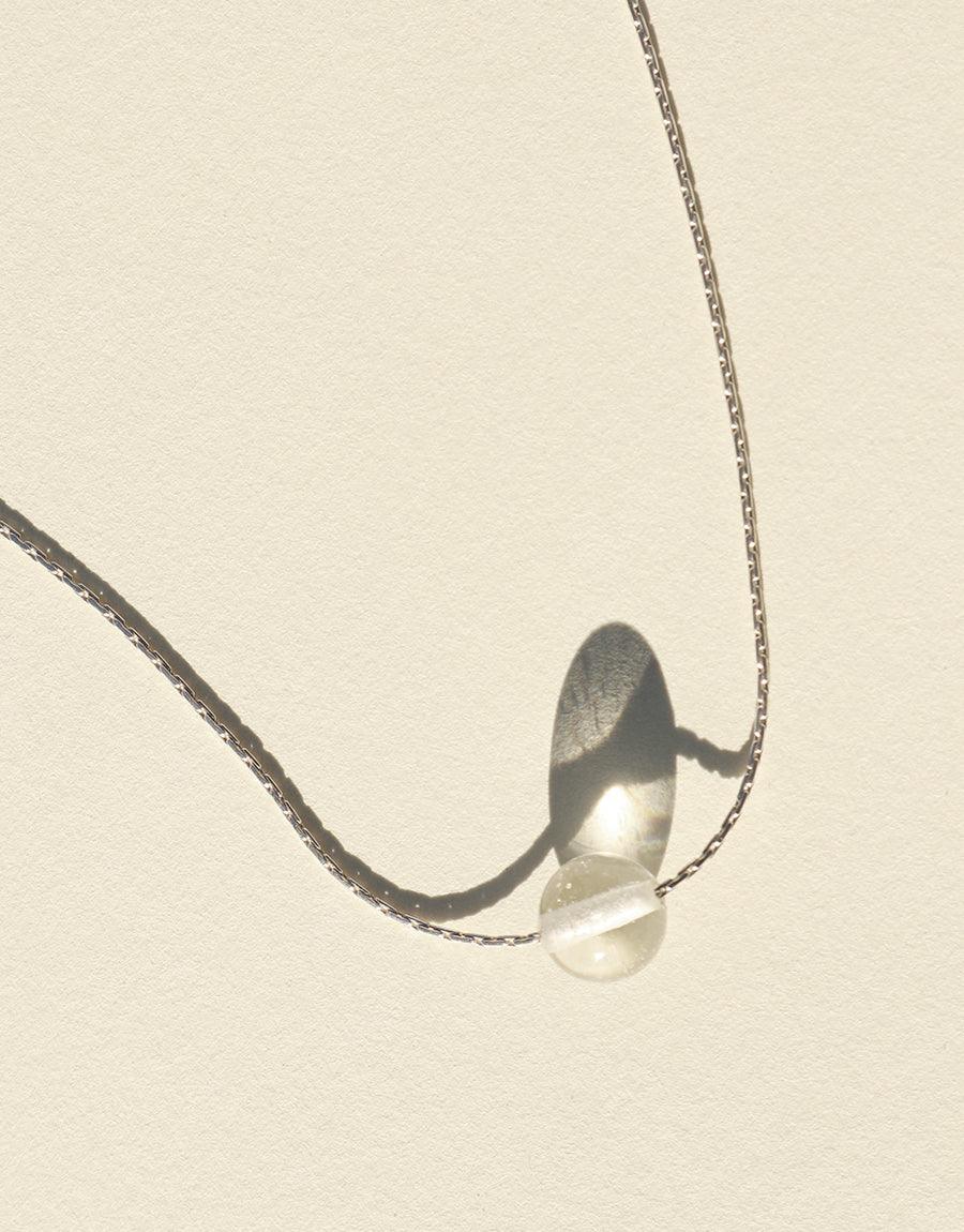 Minimal Ball Necklace featuring a delicate silver chain with a translucent glass bead, showcasing elegant simplicity and sustainable design. Eco-friendly jewelry piece handcrafted in Los Angeles. CLED Minimal Ball Necklace.