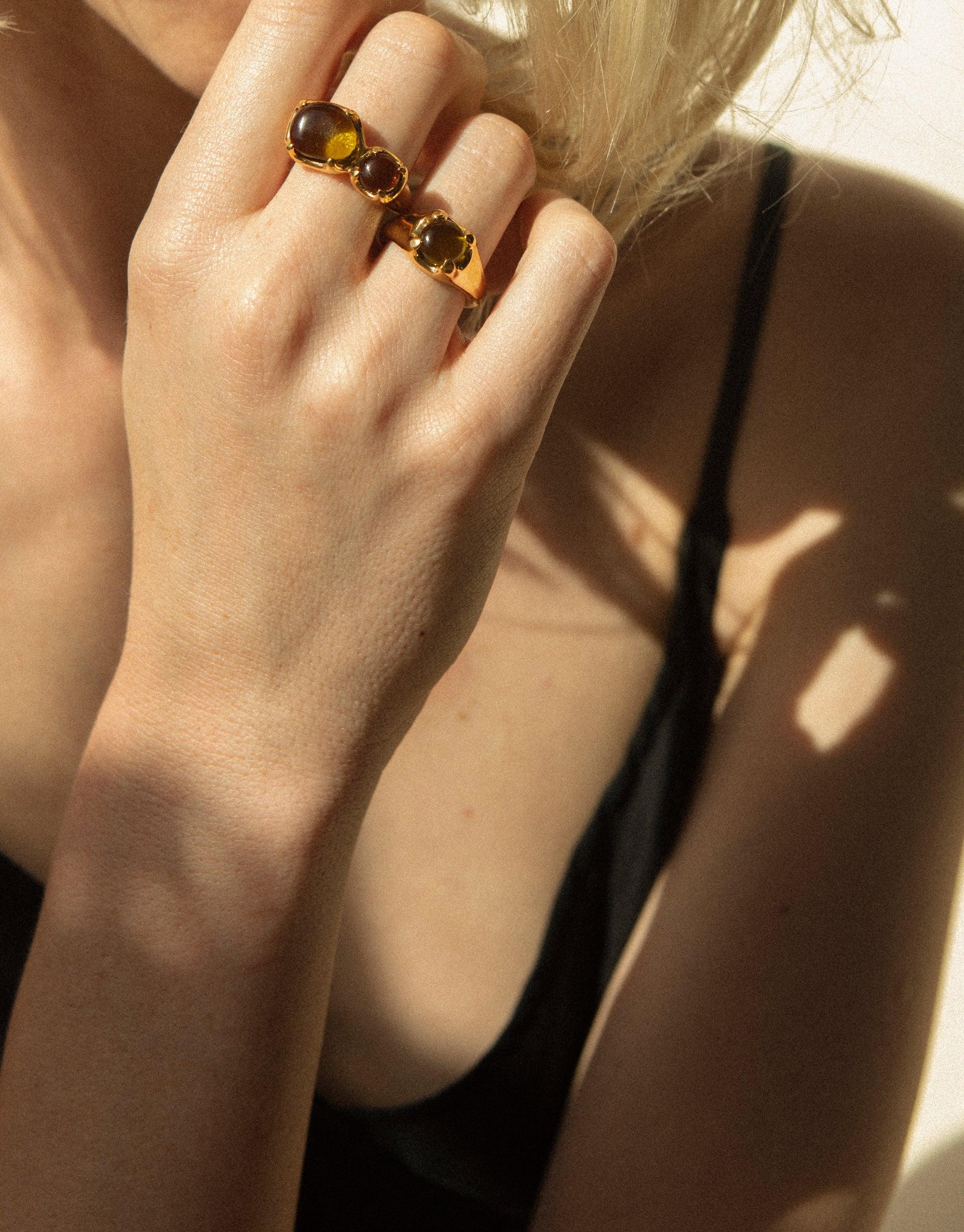 Gold-plated Beam Ring with amber eco gems worn on hand, showcasing prismatic light effect against sun-kissed skin. Handcrafted sustainable jewelry piece by CLED.