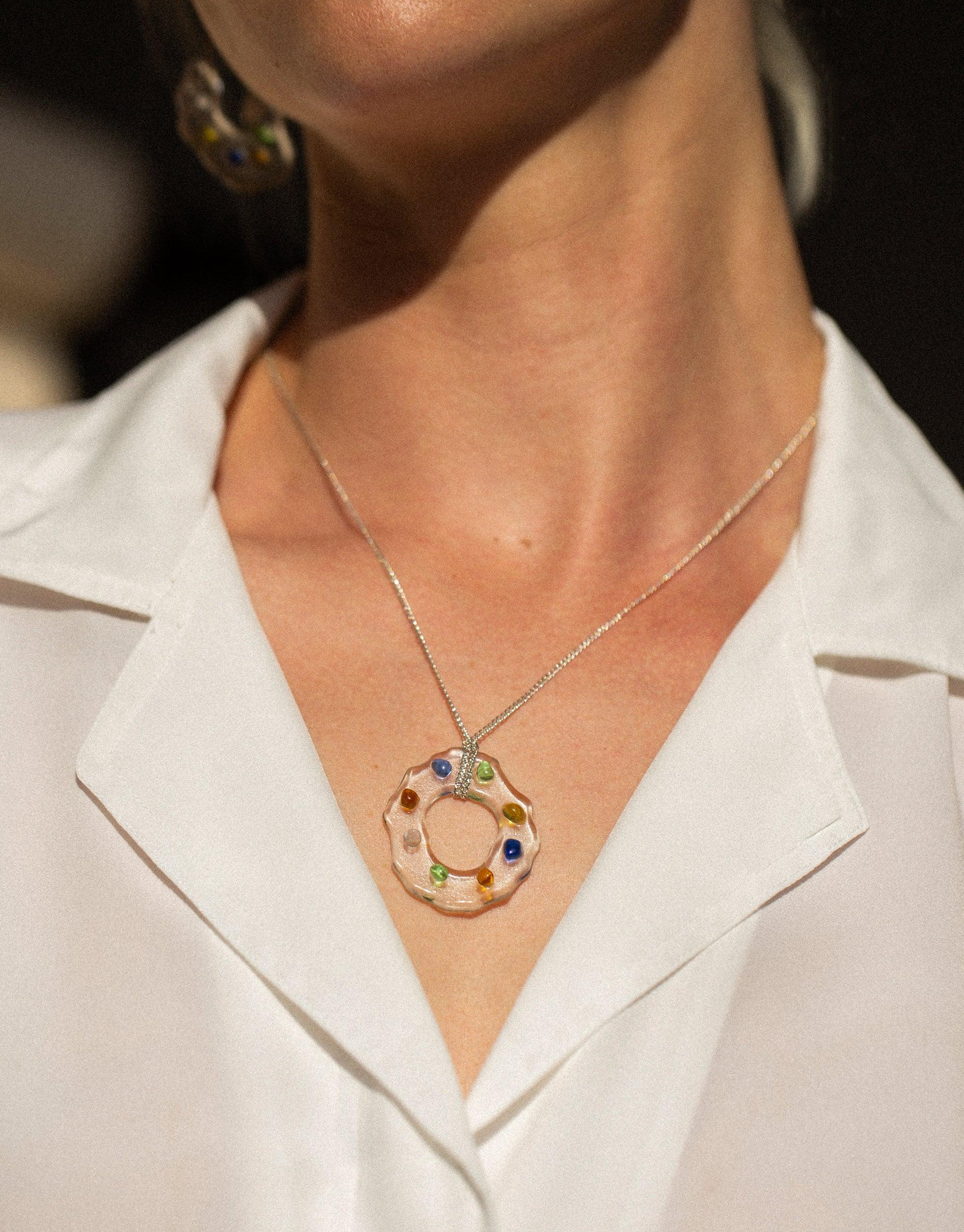 High Tide Necklace in Spectrum featuring a circular pendant with colorful eco gems upcycled from discarded glass, showcasing a prism-like effect. Delicate silver chain complements the sustainable design, perfect for eco-conscious fashion. Handmade in Los Angeles by CLED.
