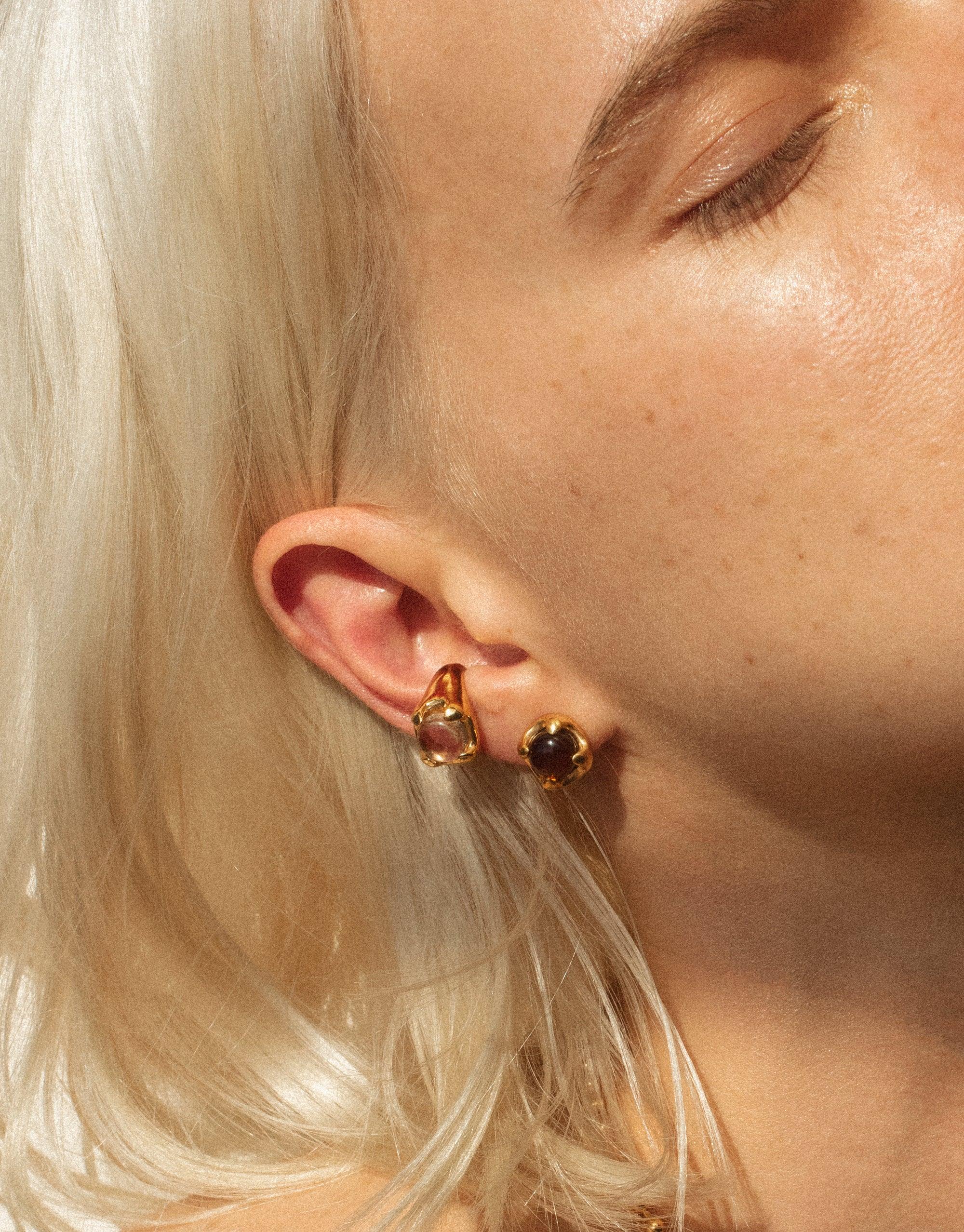 Close-up of Beam Earrings featuring eco-friendly gems in gold-plated setting, worn by a blonde model, showcasing the earrings' unique prism-inspired design and sustainable craftsmanship by CLED