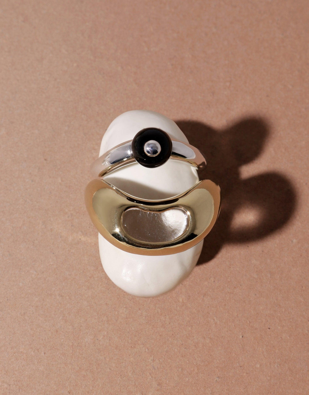 Elegant silver and gold rings with organic curves and circular details, inspired by nature's legume shapes. Pea Curve Ring | Small showcases a unique design that captures the essence of growth and transformation. CLED