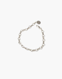 Sleek silver chain bracelet with oval links and small round charm, perfect for customization or wearing alone. Versatile accessory for creating a bold statement. Icon Chain Bracelet | A by CLED