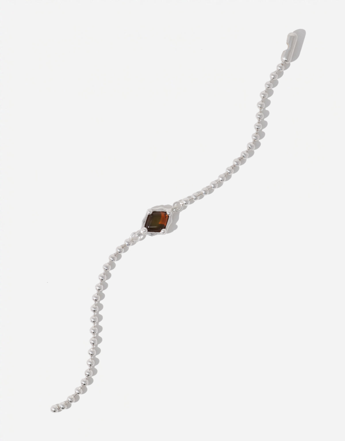 Close-up of the Interlace Bracelet showing the brown amber glass stone and the beaded sterling silver chain. Handmade in Los Angeles. Interlace Bracelet by CLED.