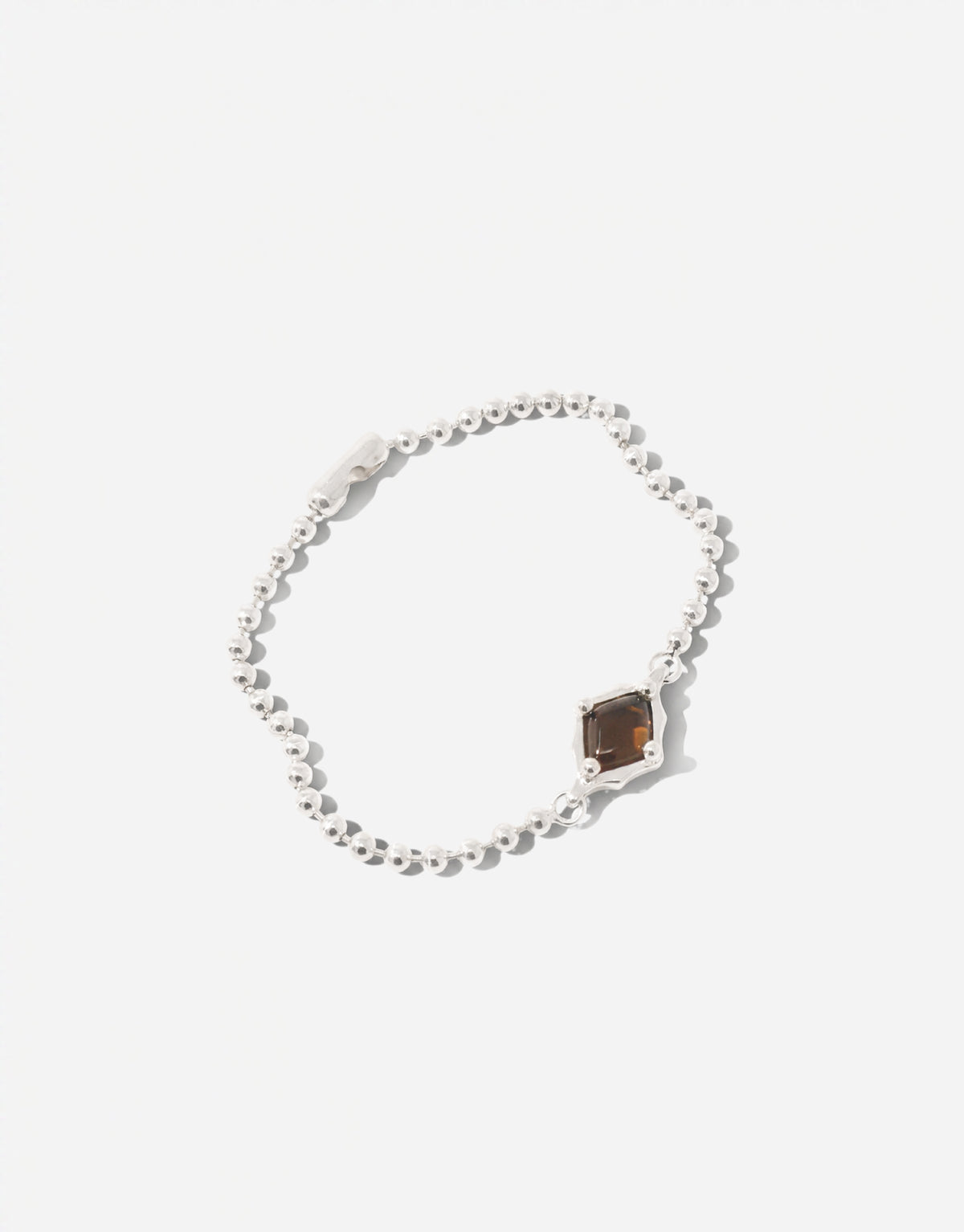 Interlace Bracelet holding a warm brown amber glass Eco Gem in a scalloped silver setting on a fine ball chain. Interlace Bracelet by CLED.