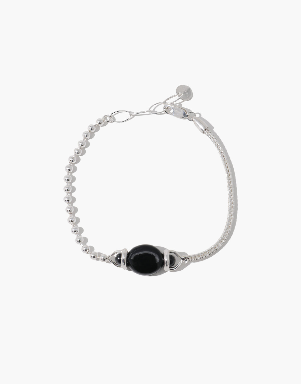 Picot Bracelet in sterling silver with a rounded black basalt glass Eco Gem held between beaded posts, where a ball chain meets a woven chain. Picot Bracelet by CLED.