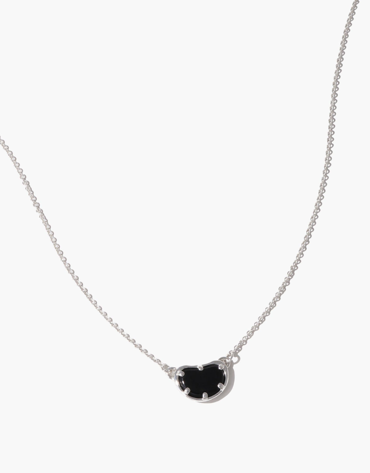 Elegant Bean Necklace featuring a delicate silver chain and a unique black bean-shaped pendant. The pendant's organic form captures nature's creativity, symbolizing growth and transformation. A sophisticated accessory inspired by the soft curves of legumes, perfect for nature lovers. Bean Necklace by CLED
