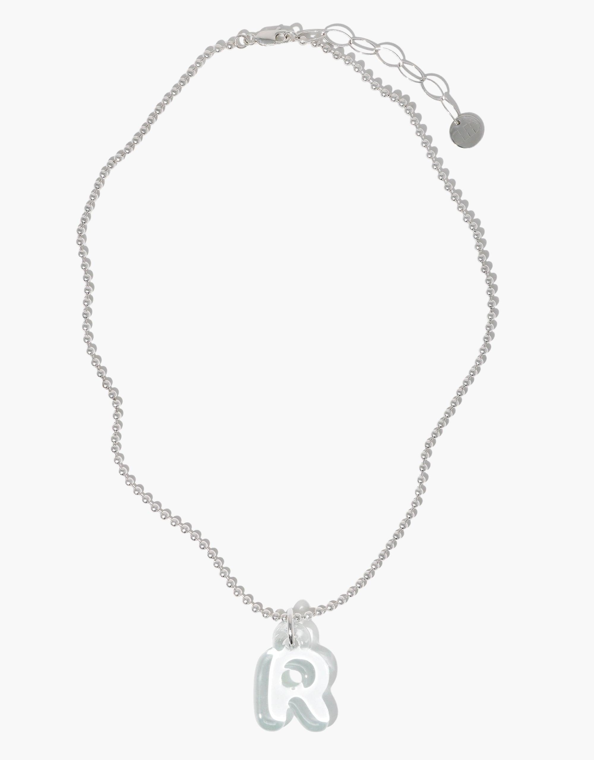 Silver Ball Chain Necklace with adjustable length and circular pendant charm. Delicate chain features a small round tag and an extender for versatile sizing. Ideal for customizing with additional charms. Perfect for everyday wear. Ball Chain Necklace by CLED.