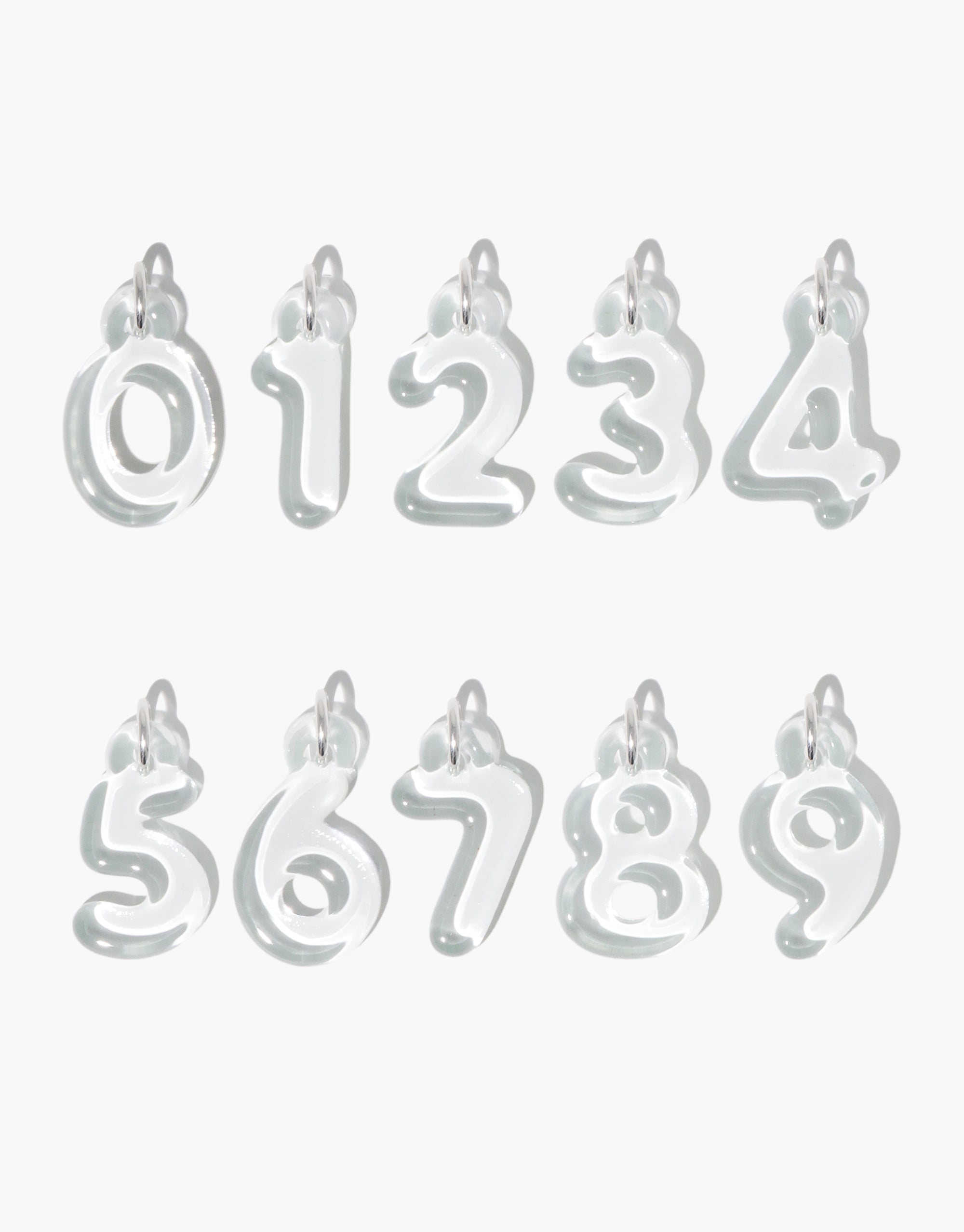 Transparent bubble-style number charms from 0 to 9, showcasing rounded, playful design. Each charm features a loop for attachment. Eco-friendly Number Charm by CLED, made from recycled window glass, perfect for personalized jewelry and unique expression.