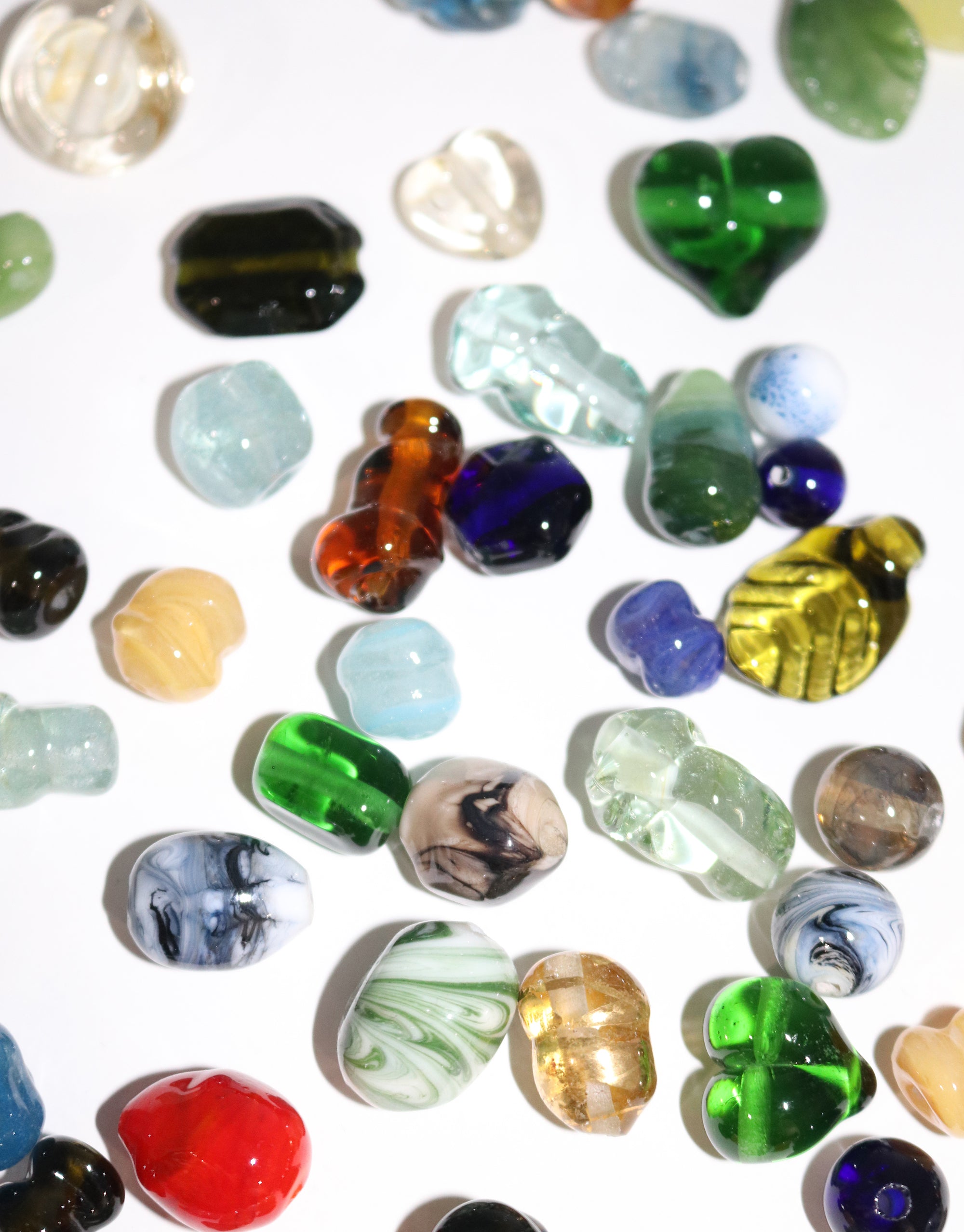 A vibrant assortment of colorful glass beads arranged together, showcasing a variety of hues and textures.