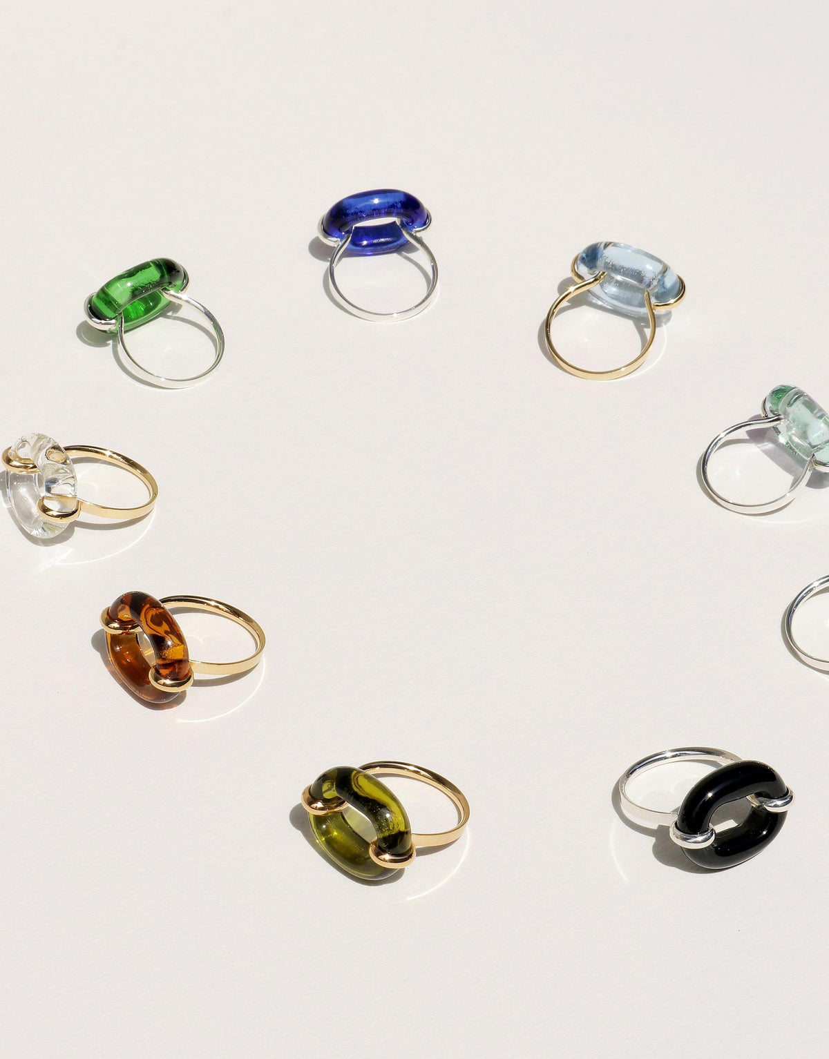 Collection of colorful glass rings showcasing various hues and styles, including the In The Loop Ring in Limited Edition "JOY on York" aquamarine color. Sustainable and upcycled jewelry pieces by CLED