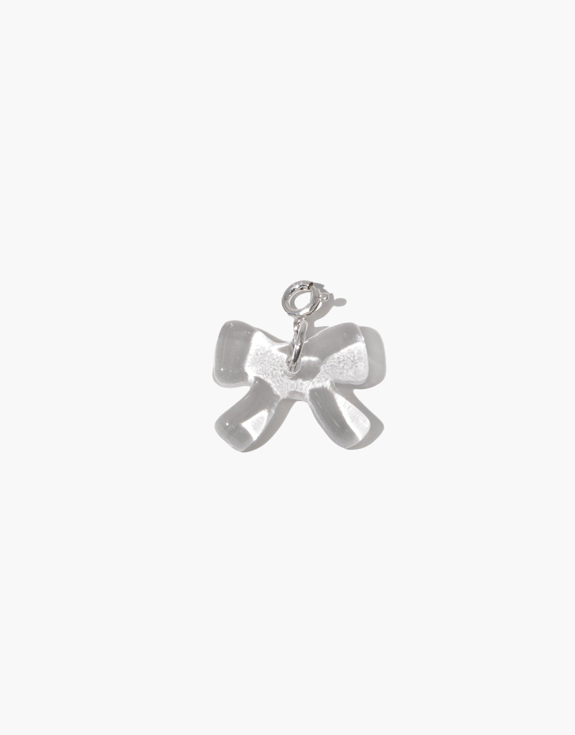 Elegant silver bow-shaped charm with delicate loops and a polished finish, perfect for adding a playful touch to jewelry. Bow A Icon Charm, a versatile accessory for necklaces and bracelets. CLED