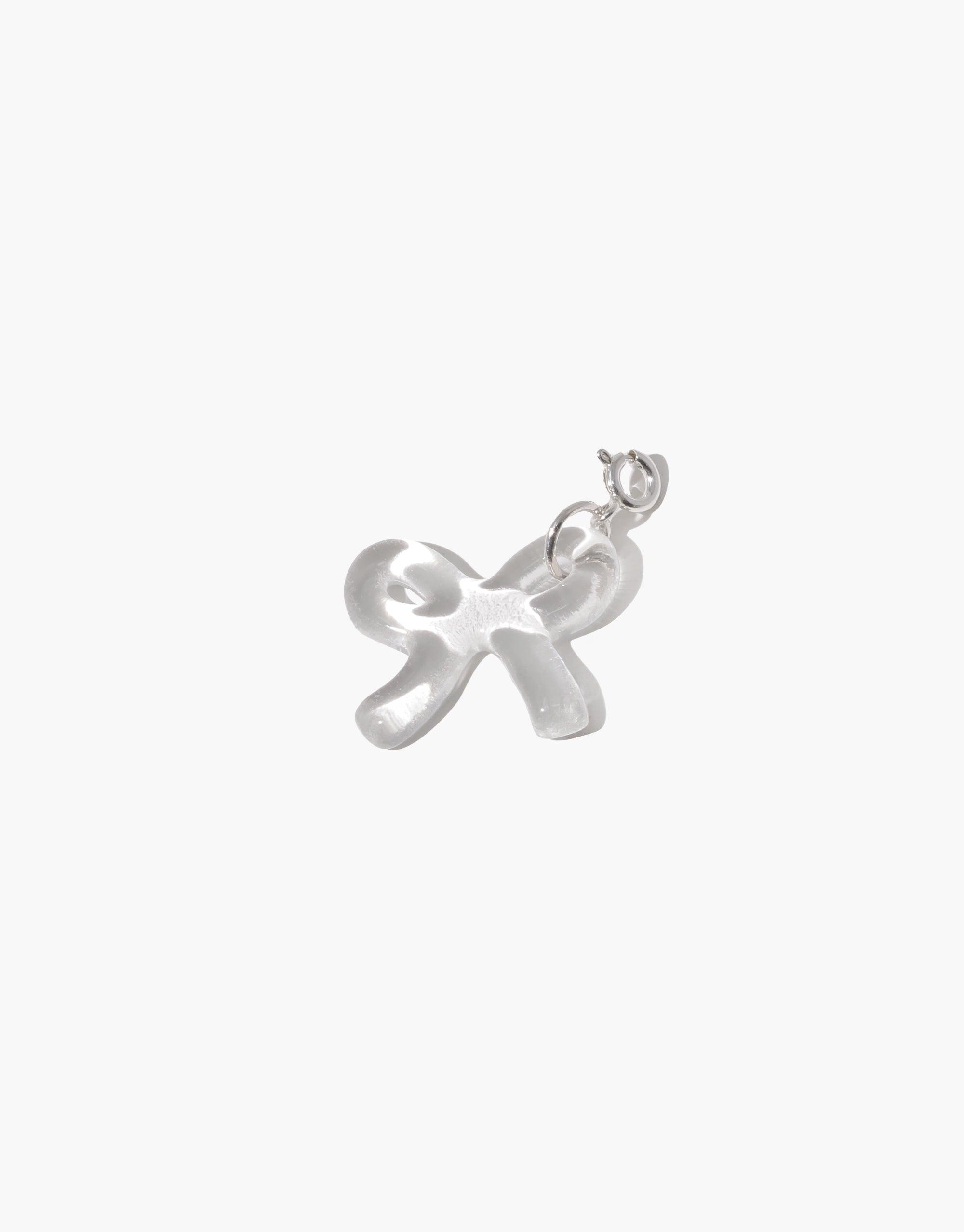 Elegant silver bow-shaped charm with smooth, rounded edges and a delicate loop for attachment. Ideal for personalizing jewelry. Bow B Icon Charm adds a playful touch to necklaces and bracelets. CLED