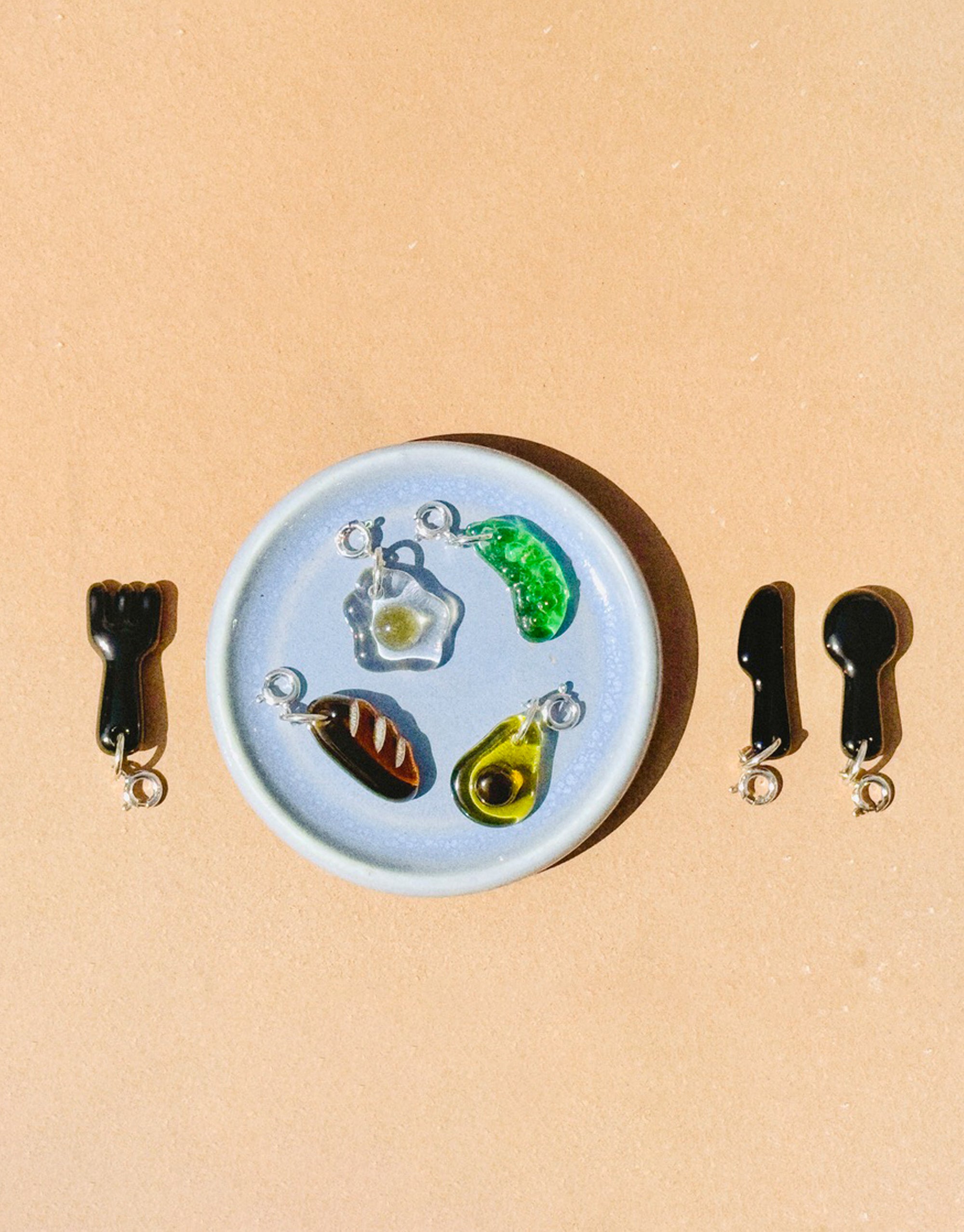 Set of small glass charms on a round blue plate against a beige background