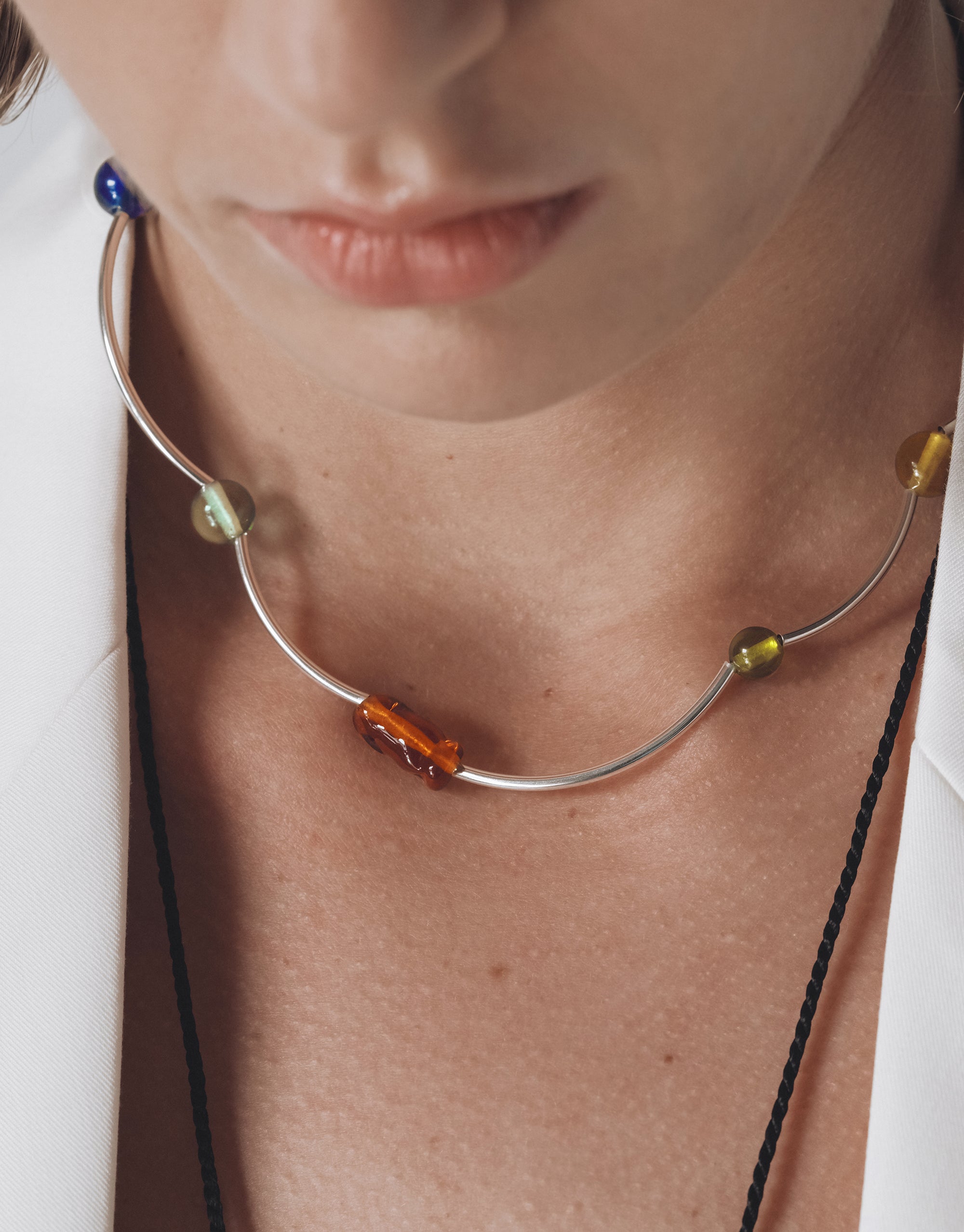 Curved silver Halo Necklace with colorful glass beads creating wave-like movement along neckline, from Goyo Collection by CLED