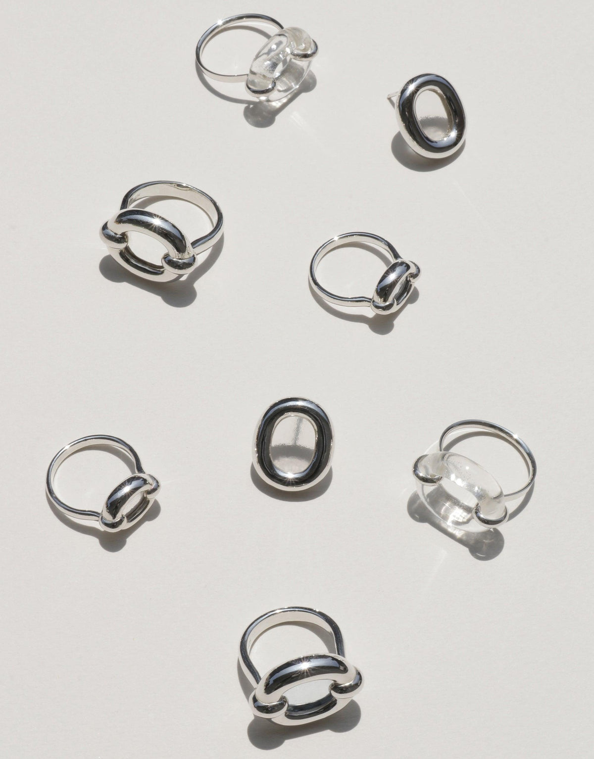 Assortment of stylish silver-toned Core Loop Earrings in large size, showcasing various circular designs with unique attachments. Elegant and minimalist jewelry pieces arranged on a light background, representing unity and upcycling. Core Loop Earrings | Large by CLED