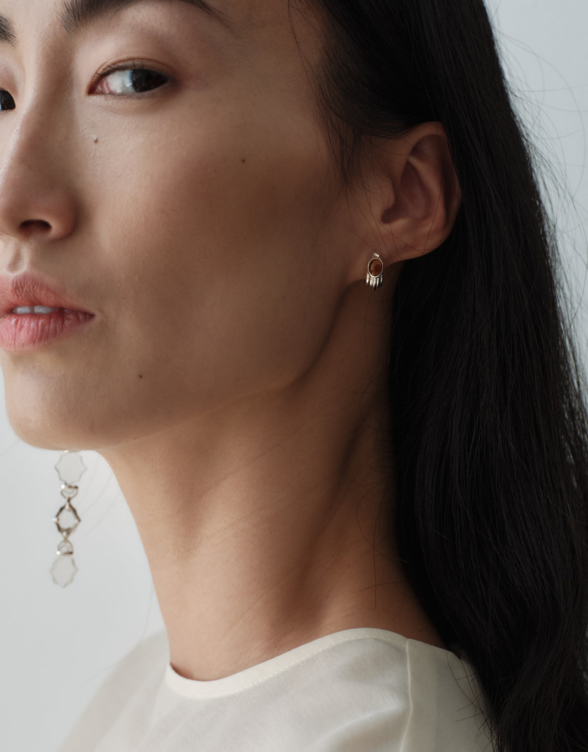 Cadence Linear Earring in clear glass catching the light along the neck, a line of faceted Eco Gems descending from the ear. Cadence Linear Earring by CLED.