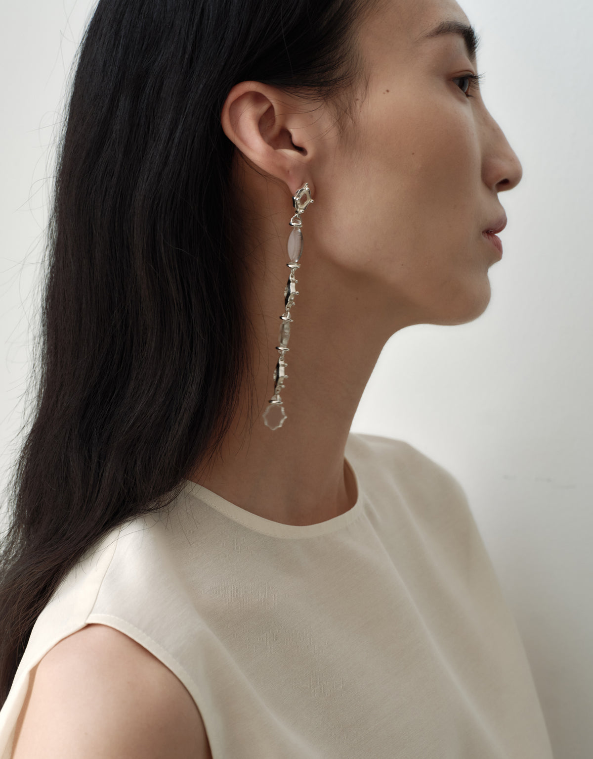 Cadence Linear Earring in clear glass, the full drop falling past the jaw in one sterling silver line. Handmade in Los Angeles. Cadence Linear Earring by CLED.