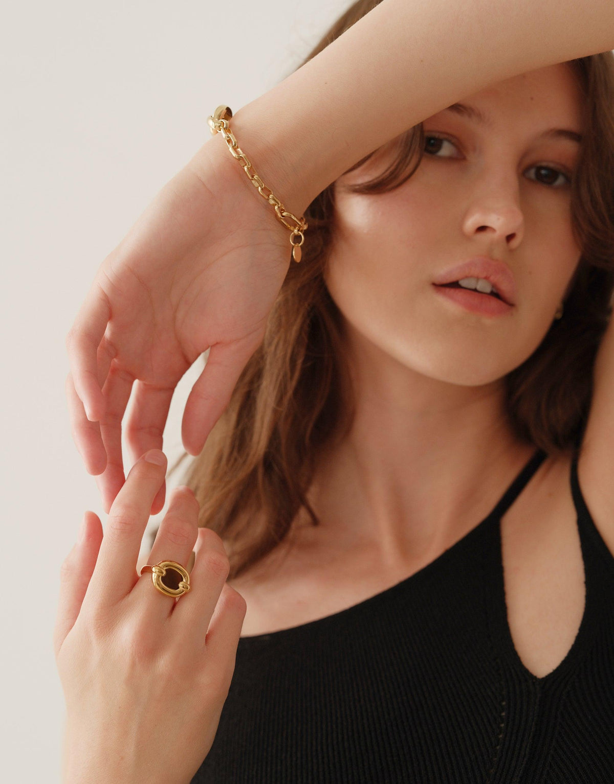 Elegant model wearing Core Loop Ring | Large, showcasing its unique metal design with eco gem center. Gold-toned ring features a functional mirror effect, perfect for quick touch-ups or capturing beautiful reflections. Stylish and practical jewelry piece by CLED.