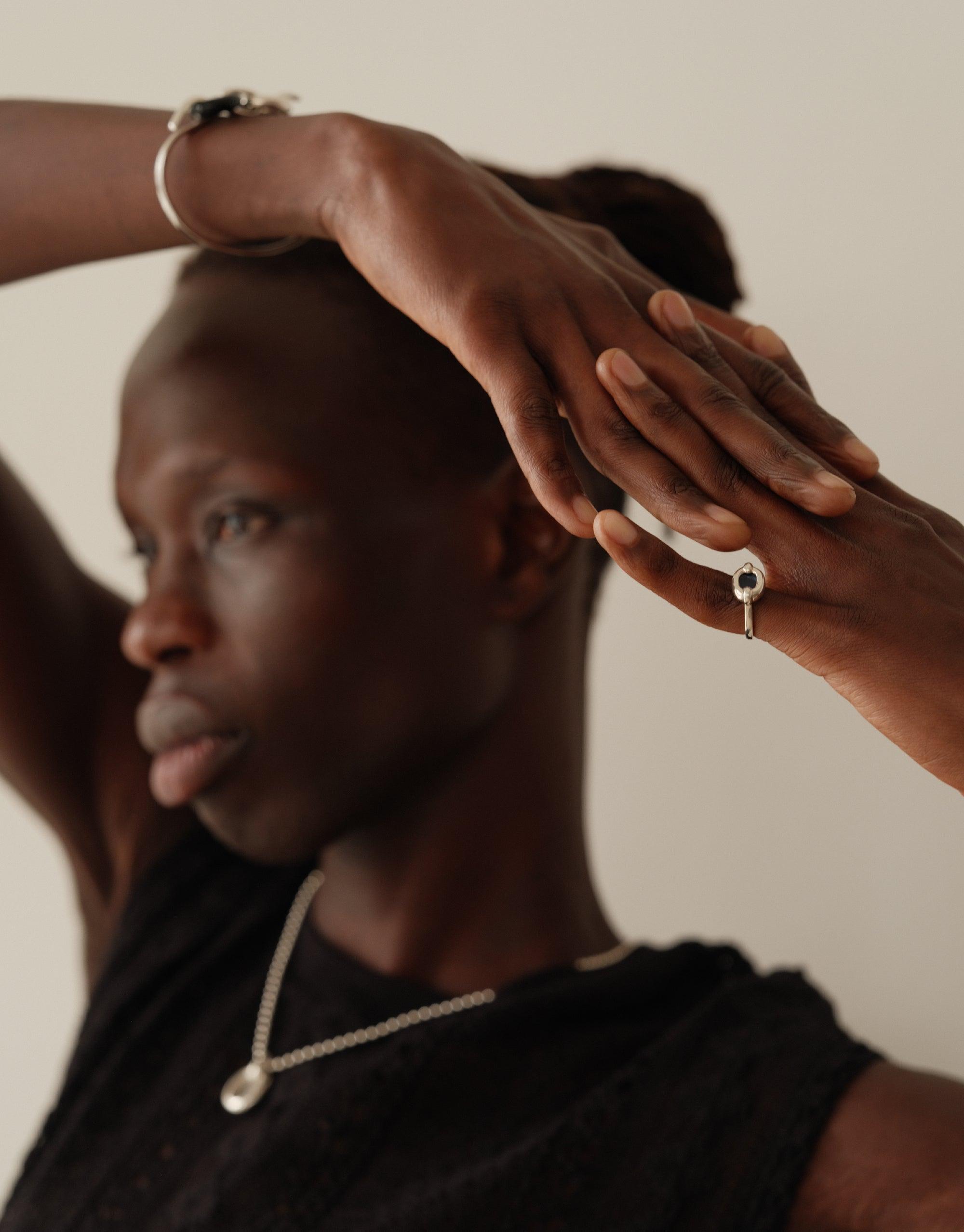 Model wearing small Core Loop Ring, showcasing delicate design on hand. Paired with matching necklace, emphasizing unity and connection in jewelry. Upcycled elegance by CLED. Core Loop Ring | Small.