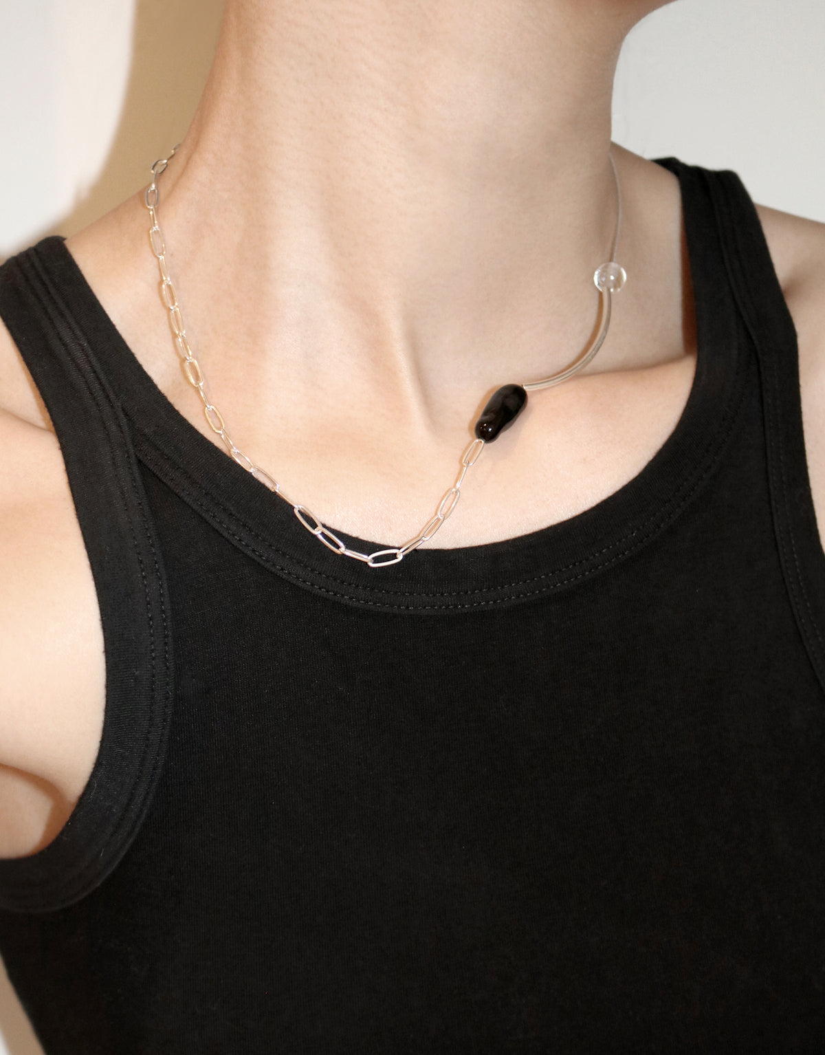 Still Necklace featuring asymmetrical silver chain with clear and black glass beads, modern minimalist design by CLED